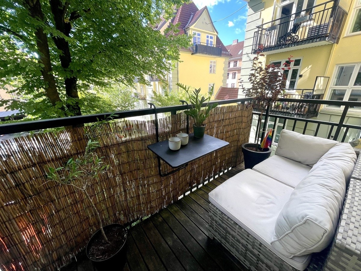 Sydvendt balkong med utesofa mot den frodige bakgården. Galleribilde