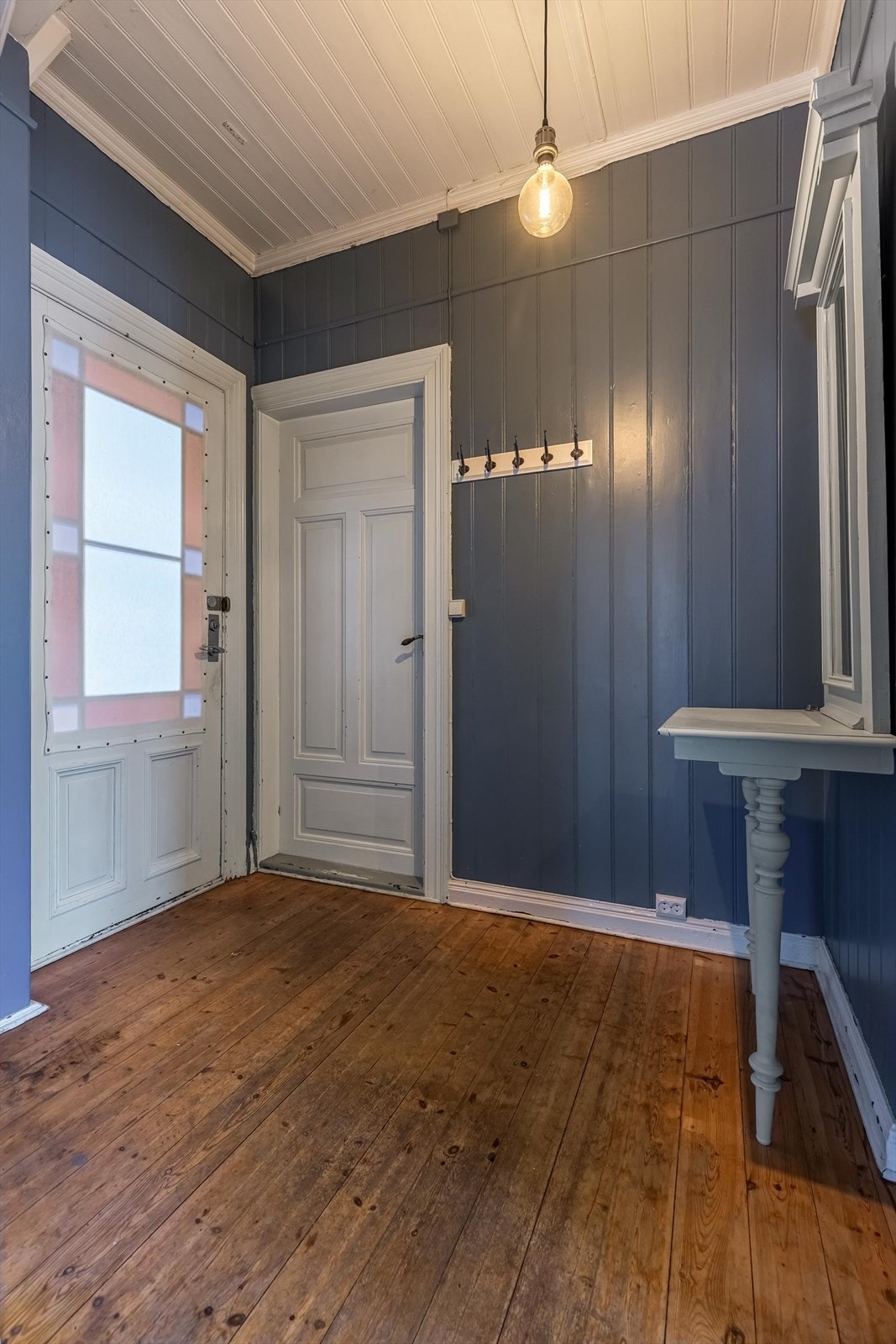Entré med originale tregulv og plass til oppheng og oppbevaring. Galleribilde