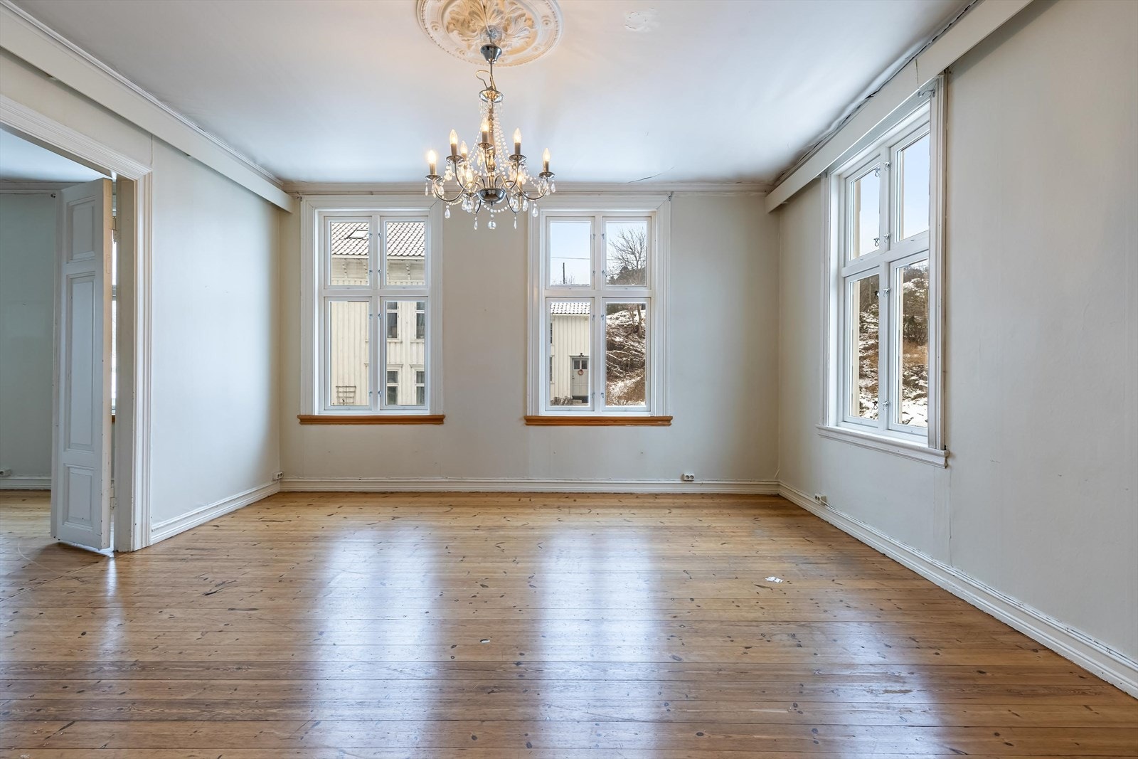 Stort oppholdsrom med gode lysforhold fra flere vindusflater og klassiske detaljer. Galleribilde