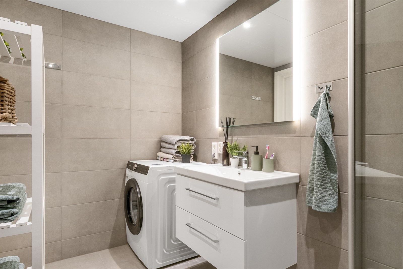 Baderommet er innredet med servantskap m/servant, veggmontert toalett med innebygget sisterne og vegghengt dusj med skjermdører i herdet glass. Galleribilde