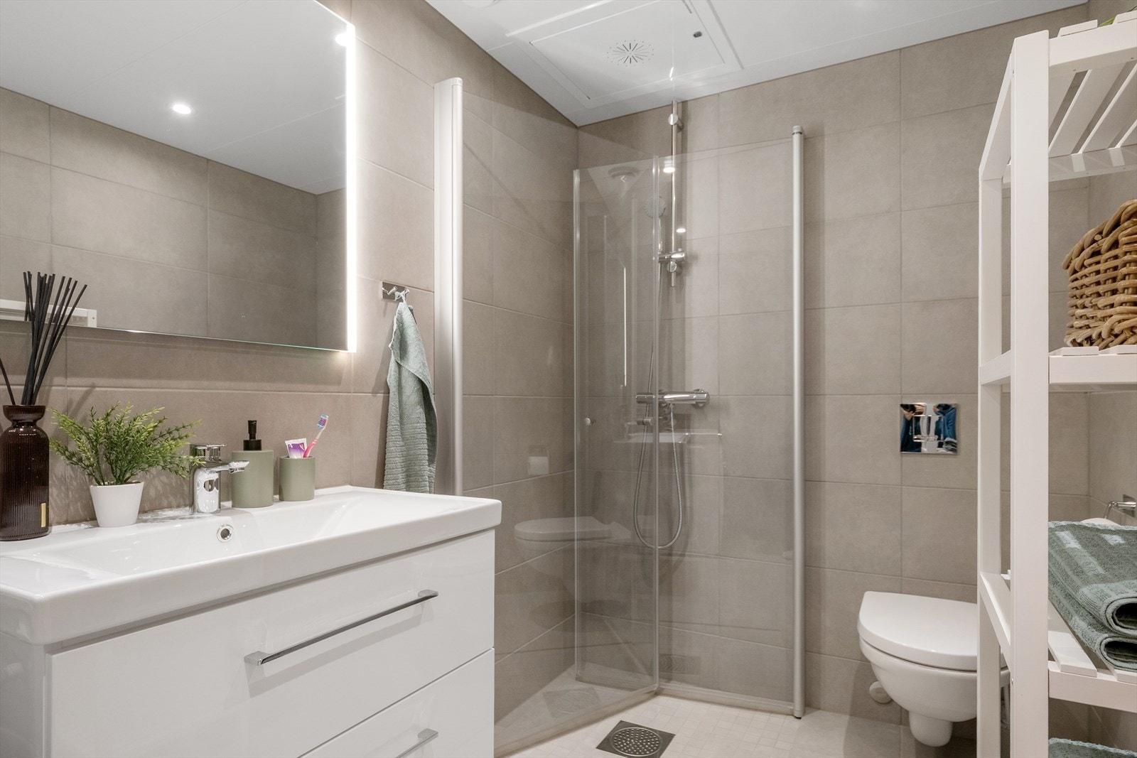 Leiligheten har et stilrent bad/vaskerom med vannbåren gulvvarme. Galleribilde