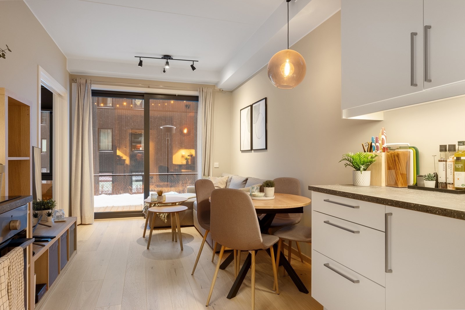 Kjøkkeninnredningen har hvite, glatte fronter og laminert benkeplate med nedfelt vaskekum og induksjonstopp. Galleribilde