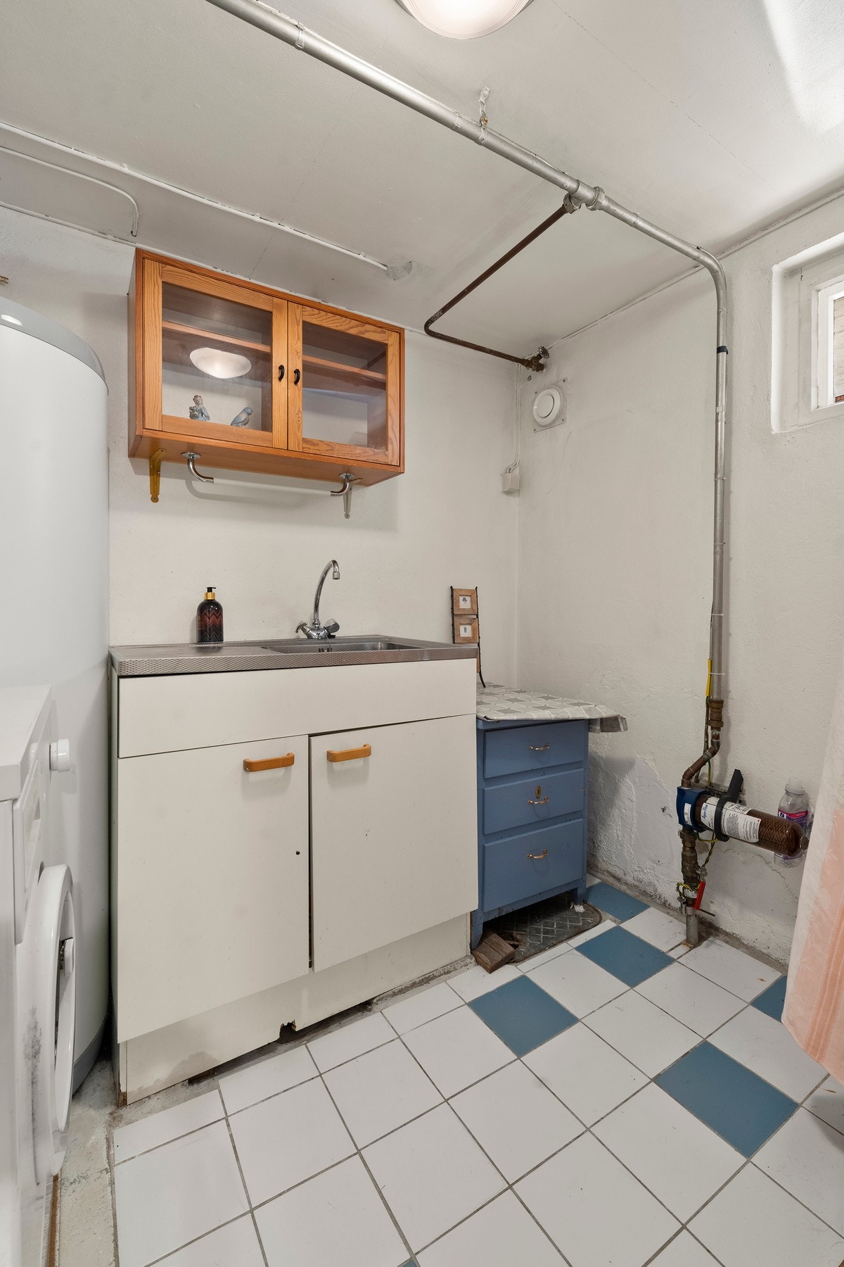 Praktisk vaskekjeller med varmtvannsbereder og plass for vaskemaskin og tørketrommel. Galleribilde