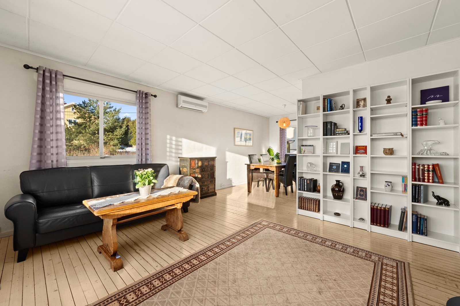 Stor og innbydende stue med rikelig plass til både sofagruppe og spisebord, et rom som inviterer til både hverdagskos og sosiale sammenkomster. Galleribilde