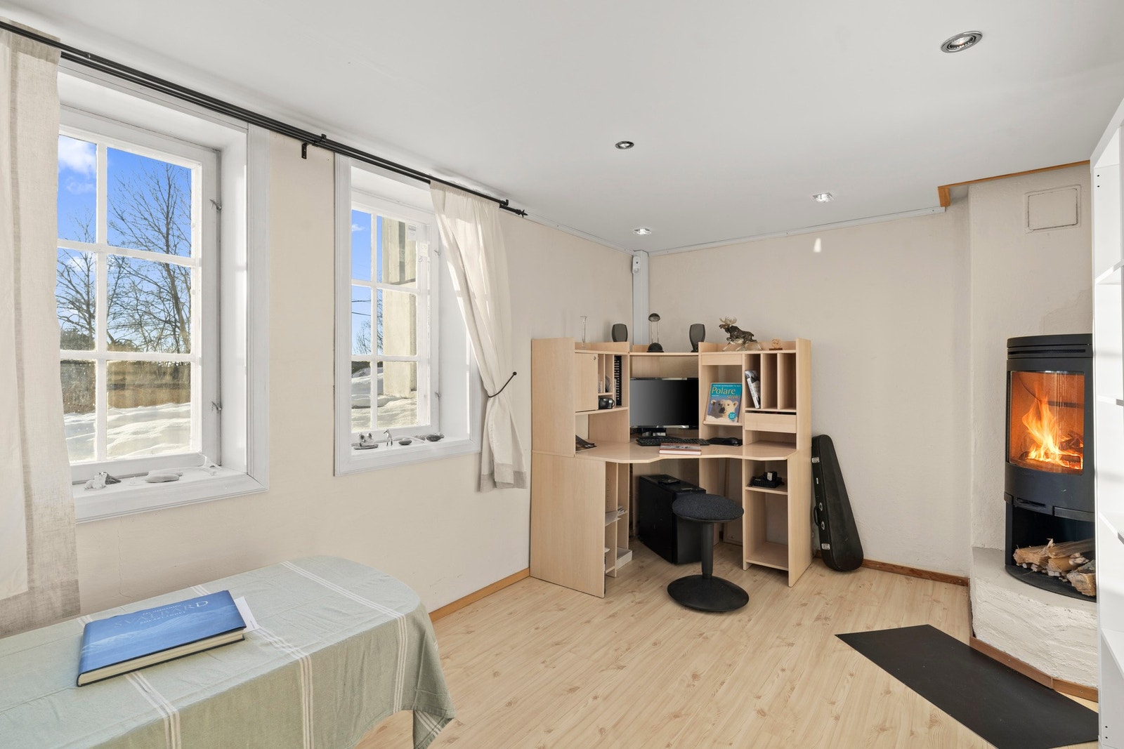 Vedovn i kjellerstuen skaper en lun og innbydende atmosfære i underetasjen. Galleribilde