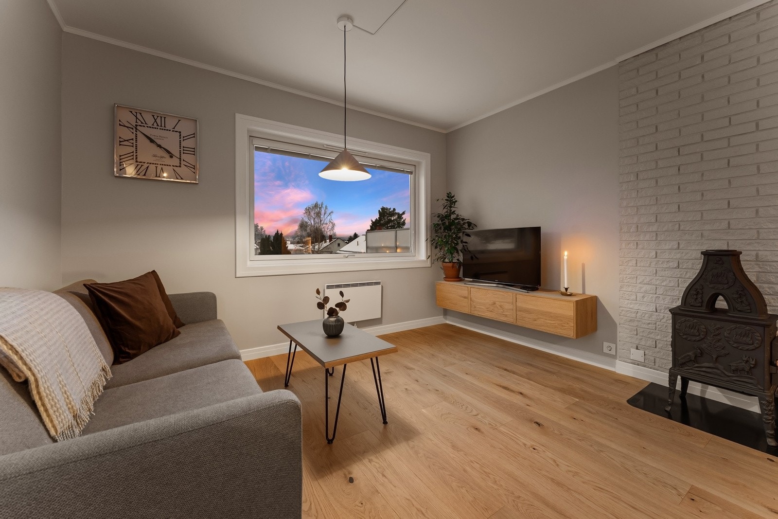 I stuen er det god oppvarming via panelovner og en sjarmerende vedovn. Galleribilde