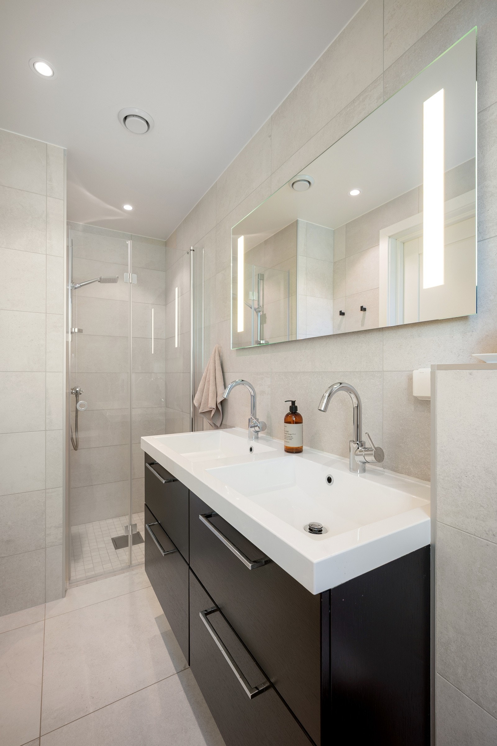 Dusjnisje med innfellbare glassvegger, håndholdt dusj og veggmontert klosett. Galleribilde