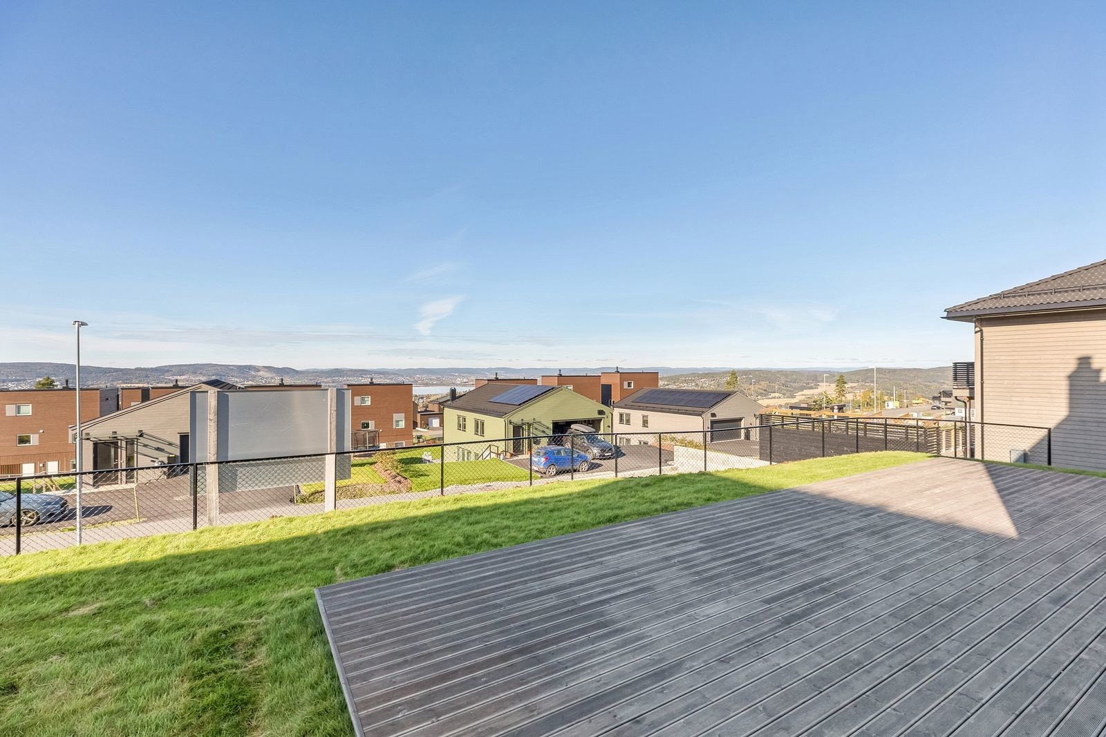 Utsikt fra terrassen. Tomten ligger høyt og fritt i terrenget, sol fra formiddag til den går ned. Galleribilde