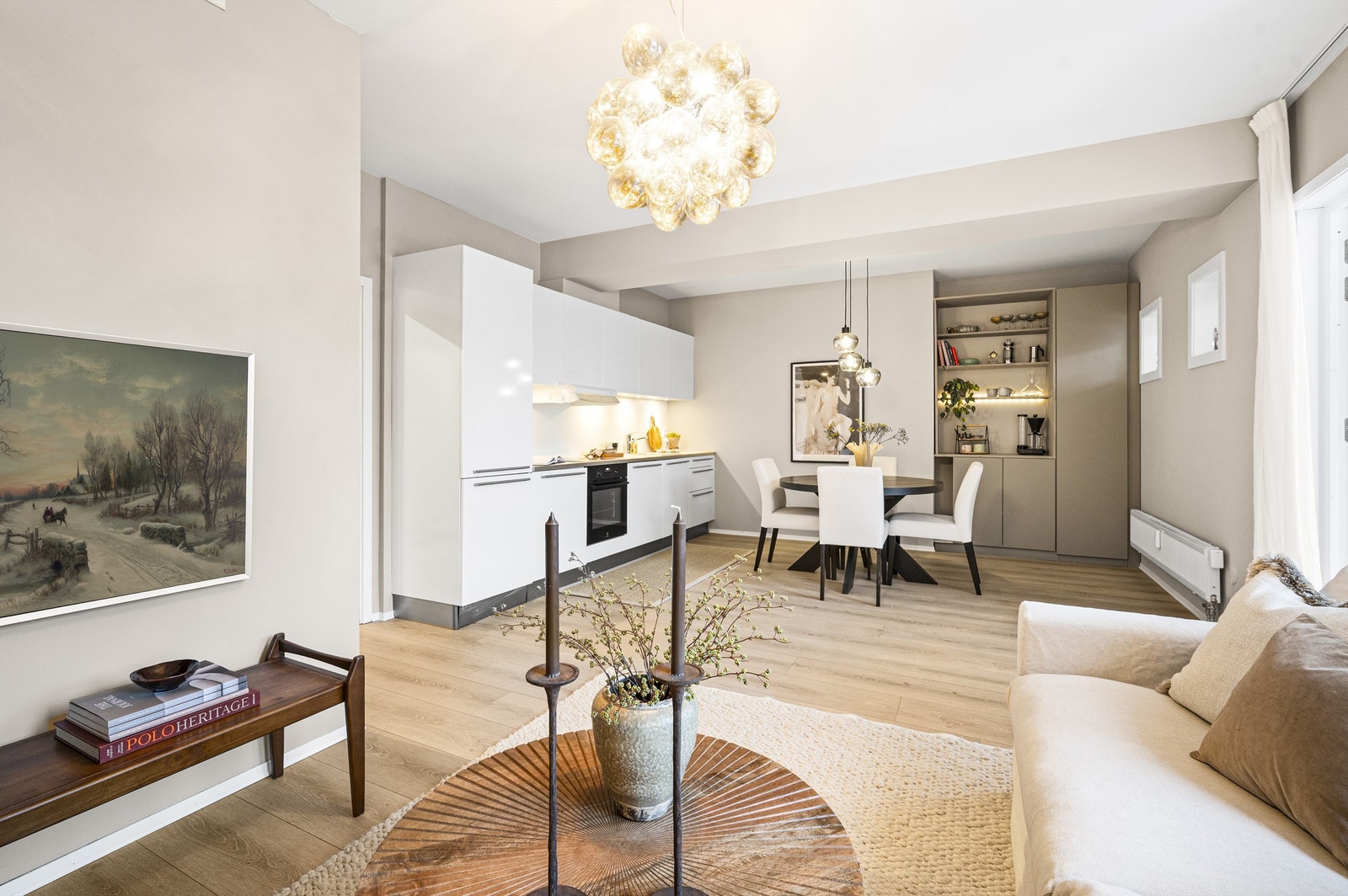 Gjennomgående én-stavs laminatgulv binder sammen stue og kjøkken på en elegant måte. Galleribilde