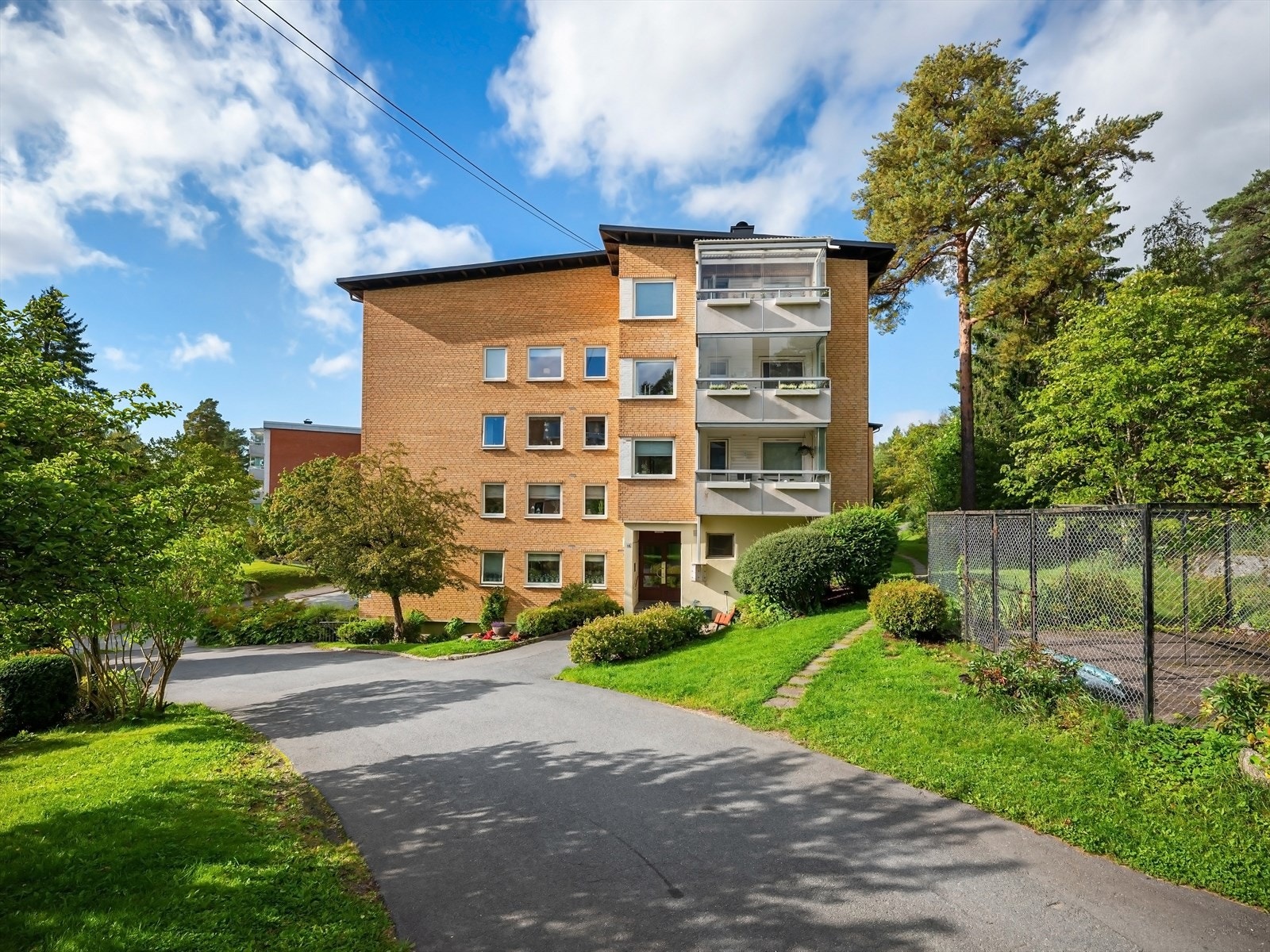 Pene, velstelte utearealer med gangstier, plen, trær og beplantning. Galleribilde