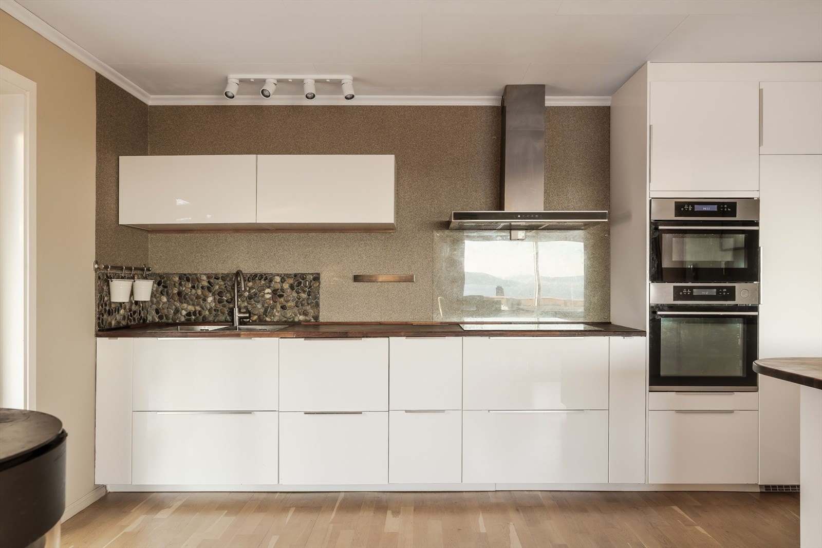 Innredning med glatte fronter. Benkeplaten er av laminat. Kjøkkenventilator med avtrekk rett ut. Galleribilde