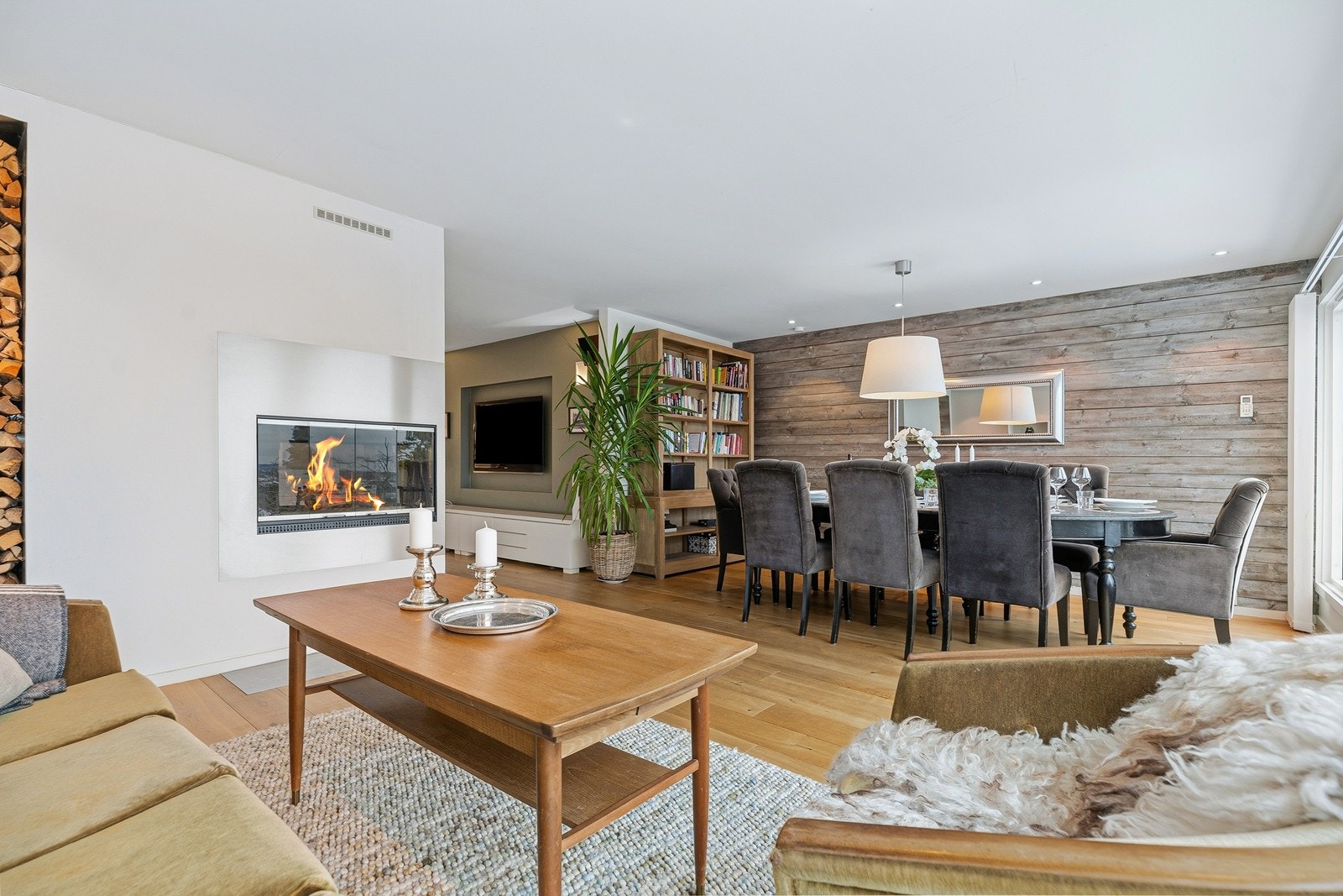 Det er god plass til ulike sofagrupper og spisegruppe. Den flotte peisen skaper et skille mellom stuene samtidig som det forblir en åpen og luftig atmosfære. Galleribilde