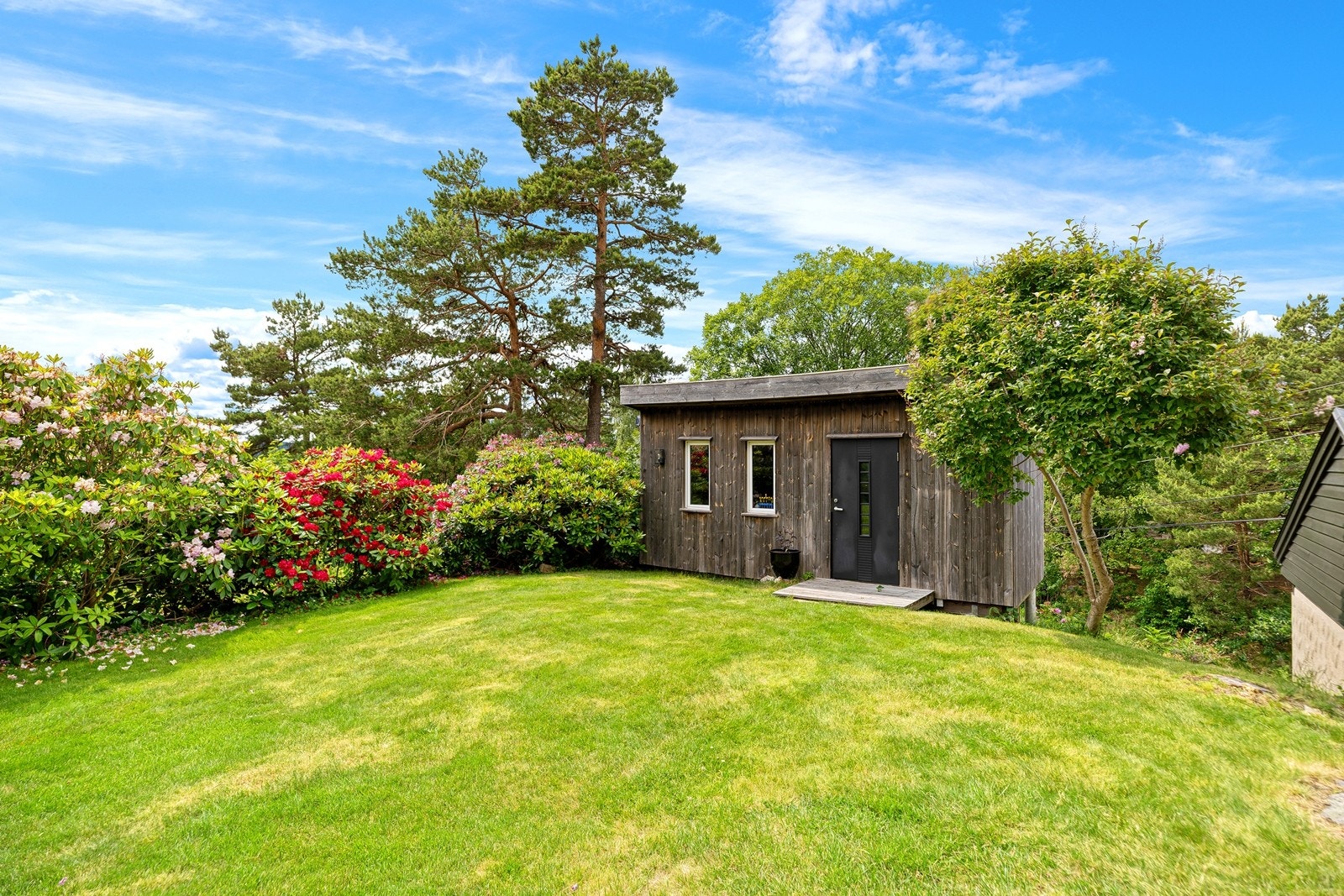 Det er en redskapsbod i hagen med plass til verktøy m.m. (Det gjøres oppmerksom på at deler av boden går på kommunal tomt - se vedlagt kart av tomtegrense i prospekt). Galleribilde