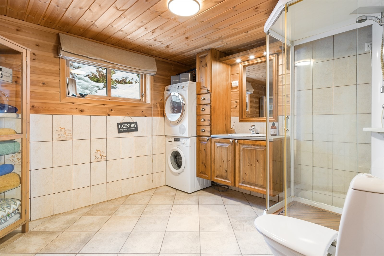 Bad/vaskerom med fliser på gulv, delvis vegger og i dusjsonen. Varmekabler i gulv. Galleribilde