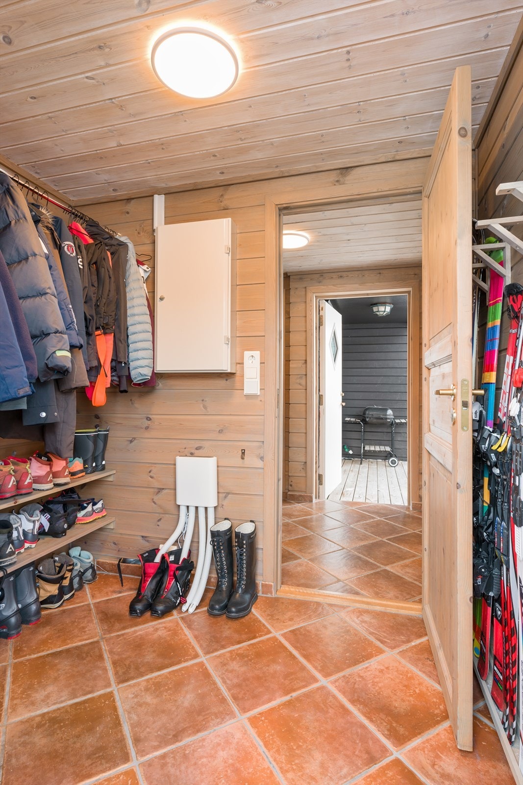 Entre/vindfang med god og praktisk innredning til klær, sko og ski. Fliser på gulv med varmekabler under. Galleribilde