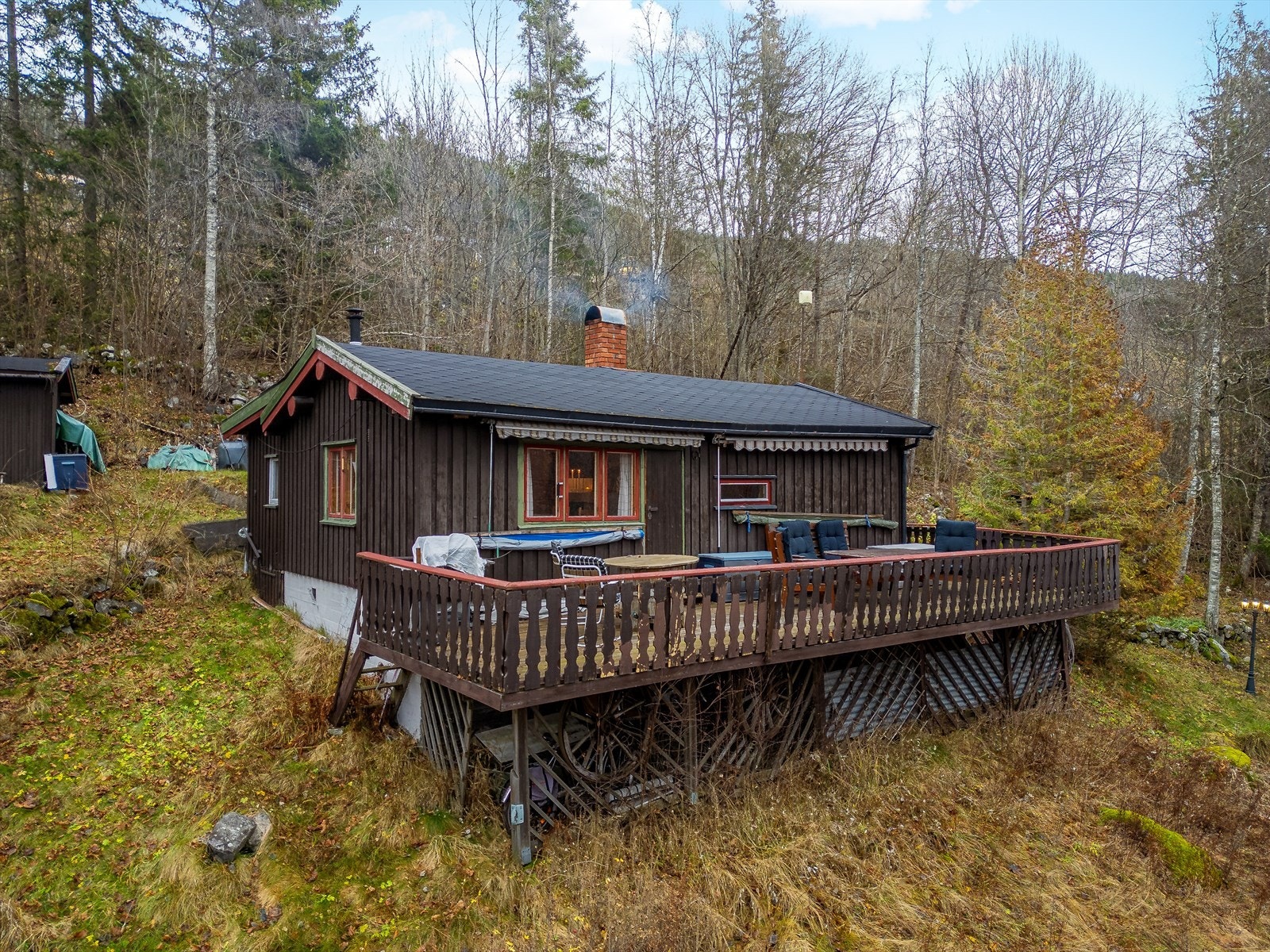 Tomten består av gress, støttemurer og beplantning, samt deler naturtomt. Det er trapp i tre fra parkeringsområde til hytta. Galleribilde