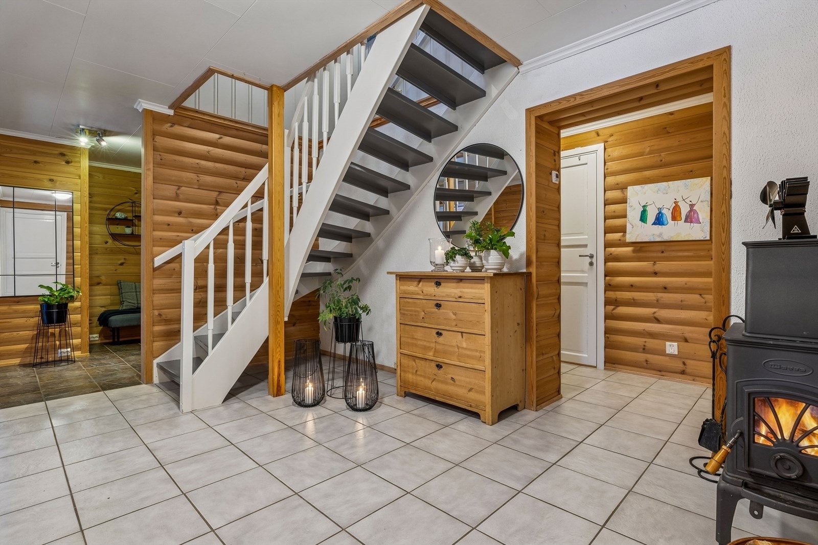 Hallen i underetasjen har flislagt gulv med gulvvarme og et ildsted som gir ekstra varme og hygge. Galleribilde