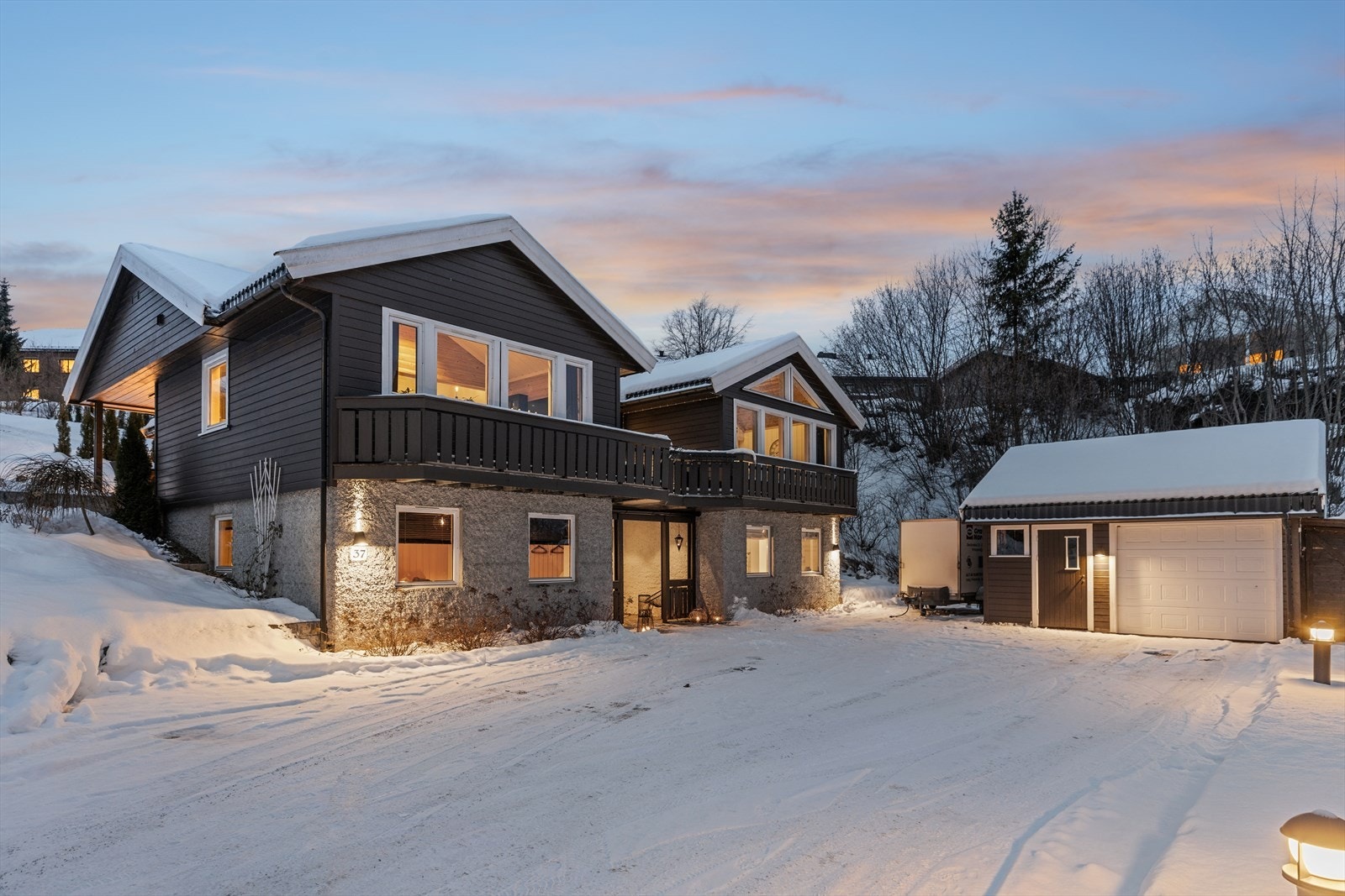 En innholdsrik enebolig med stor, asfaltert gårdsplass og egen garasje. Galleribilde