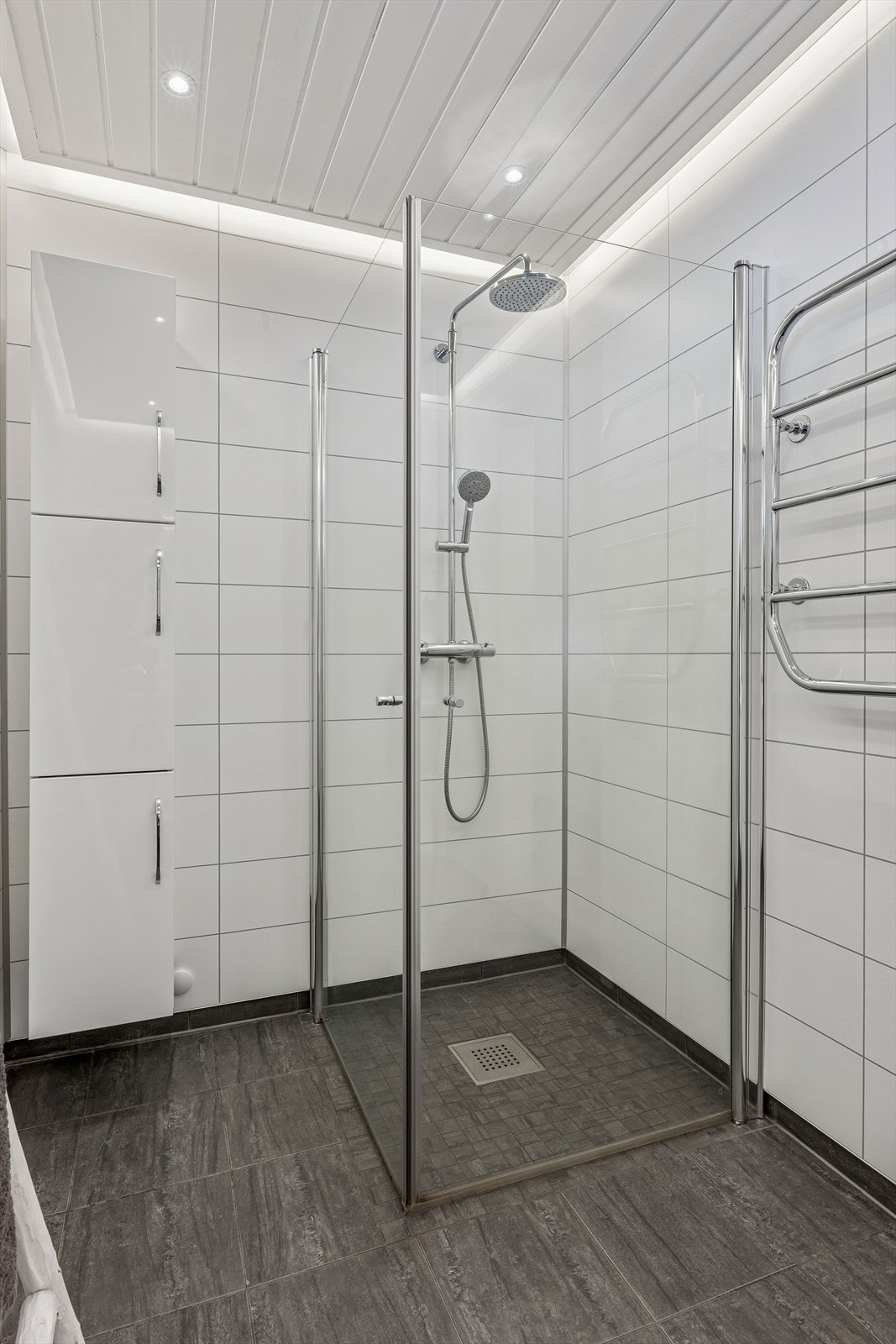 Rommet er utstyrt med en romslig dusj med glassdører og moderne innredning. Galleribilde