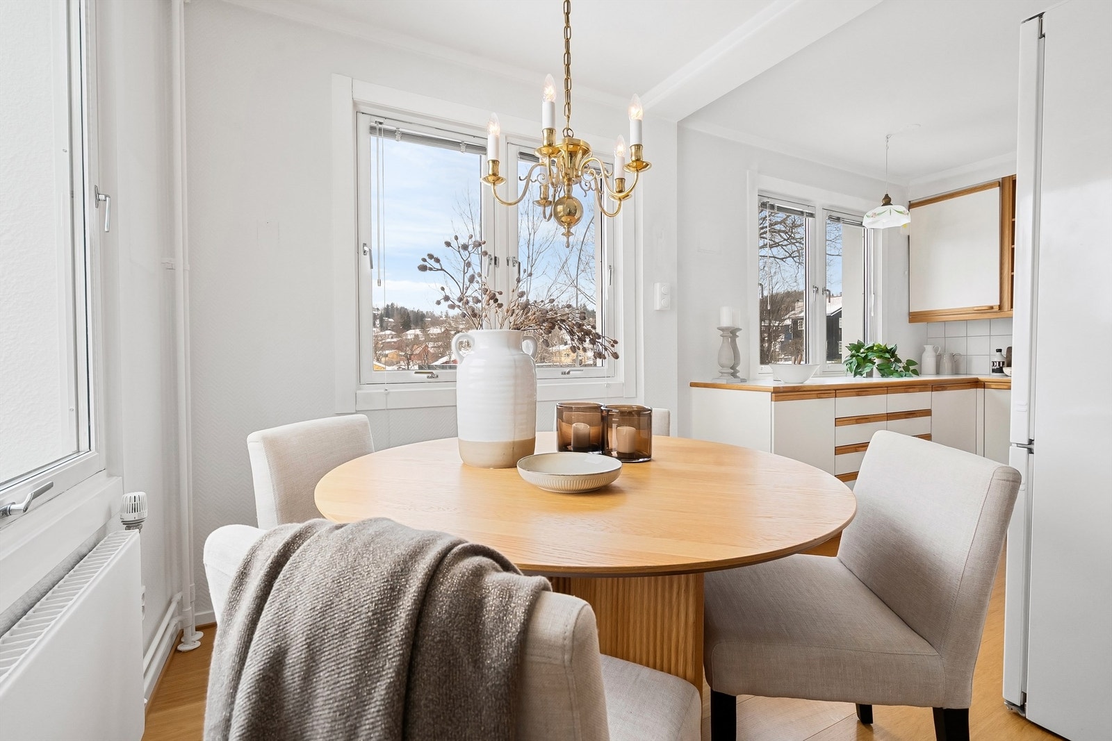 Spisegruppe med naturlig plassering mellom stue og kjøkken med utsikt mot hyggelig nabolag. Galleribilde