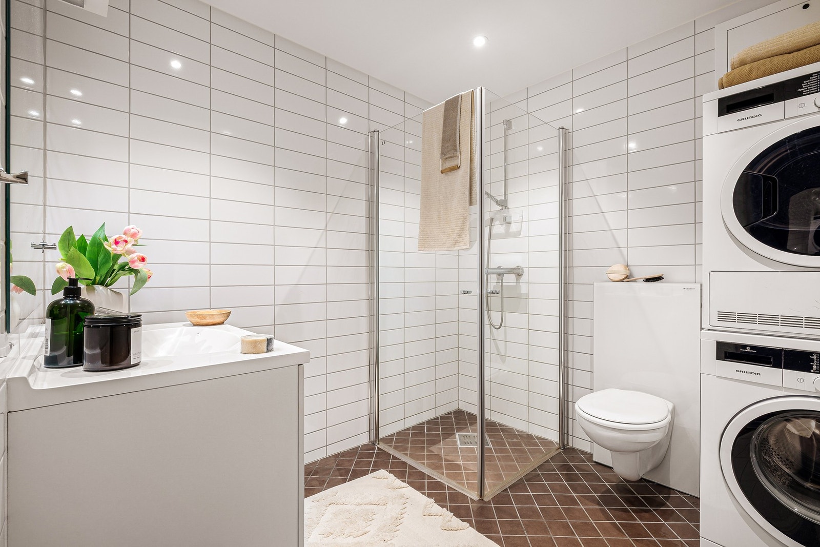 - Badet er lyst og klassisk utformet med helflisede overflater, vannbåren gulvvarme, vegghengt toalett, dusj med glassdører og servant med møblement - Galleribilde