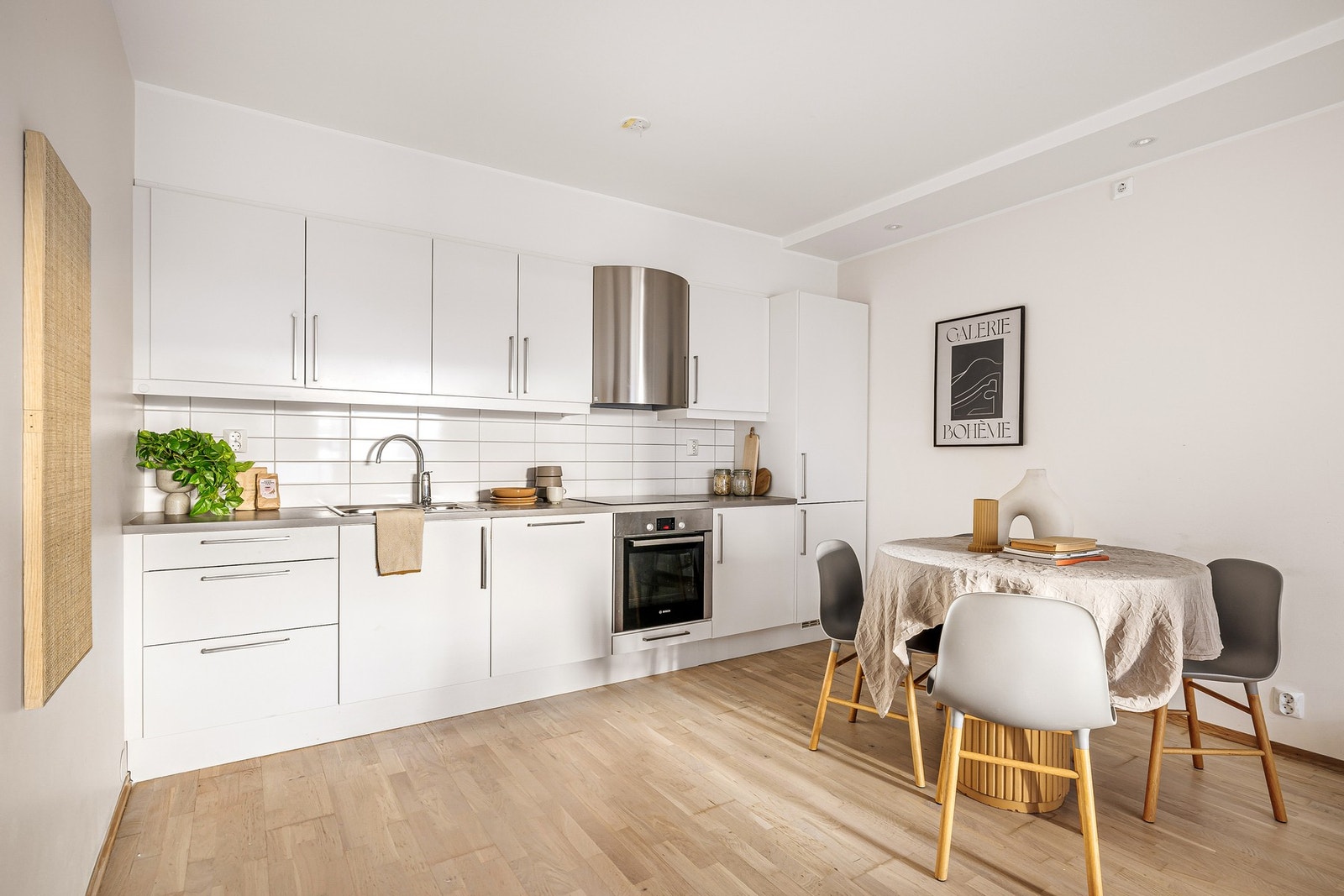 - Kjøkkenet fremstår lyst og moderne med slette fronter, laminat benkeplate og fliser mellom benk og overskap - Galleribilde