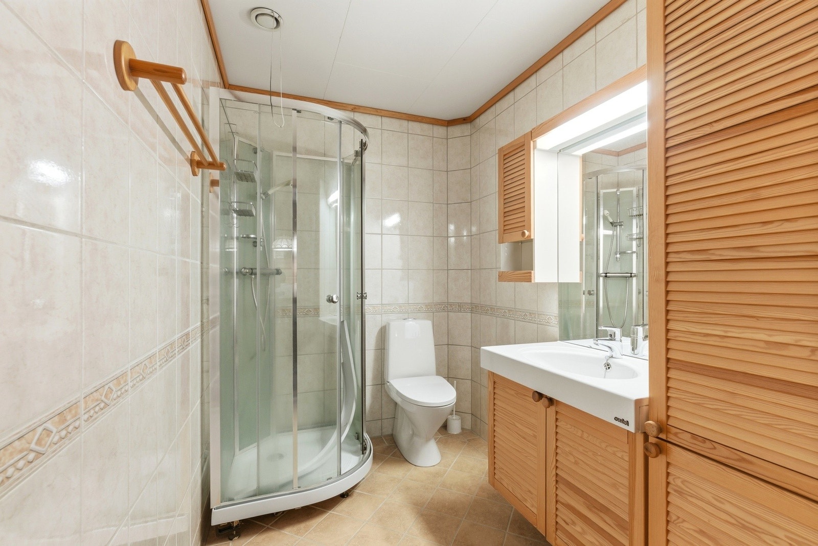 Flislagt bad med varmekabler i gulvet. Innredning med nedfelt servant, toalett og dusjkabinett. Galleribilde