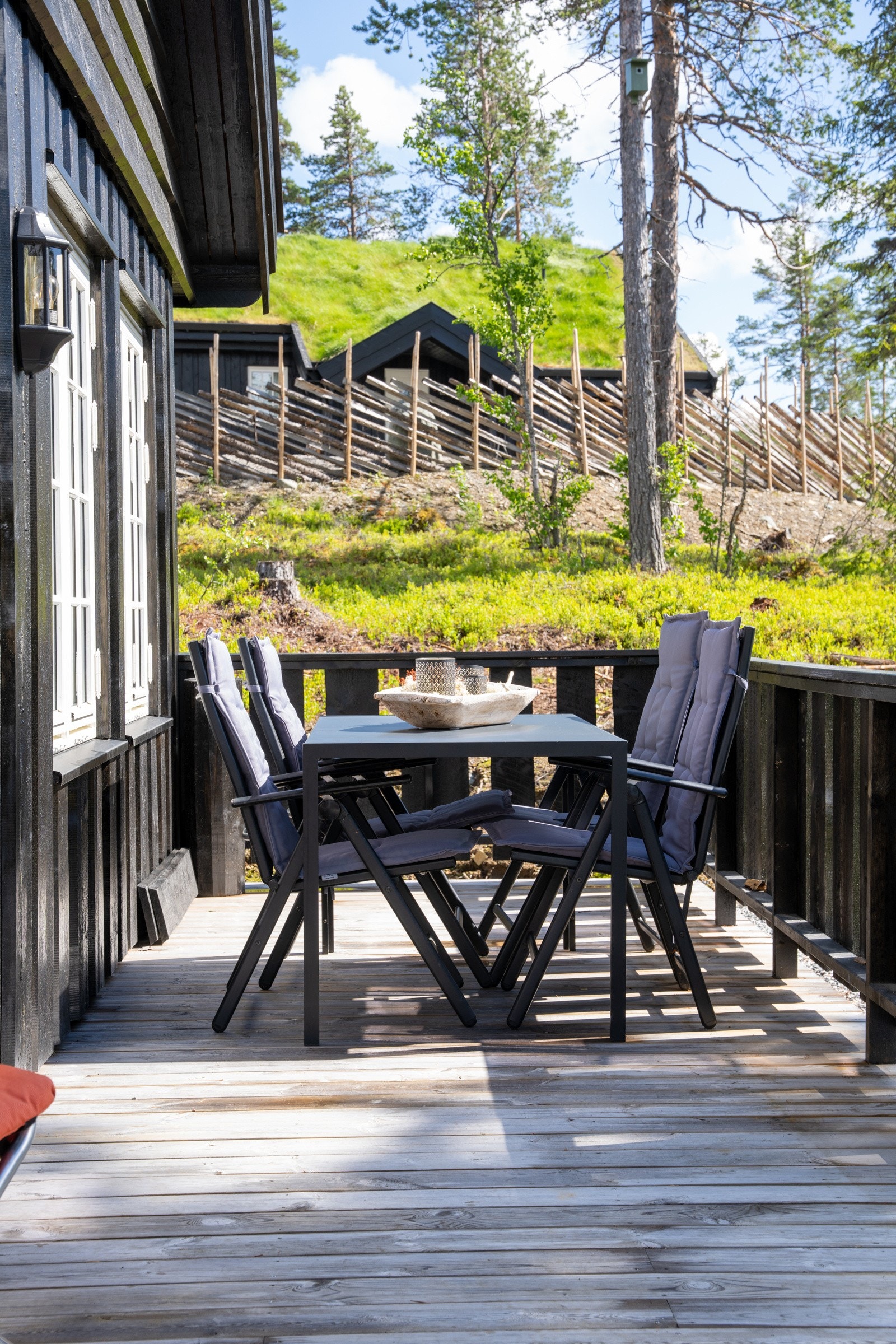 Det er en romslig terrasse som strekker seg over to sider av hytten med god plass til spisebord med flere sitteplasser. Galleribilde