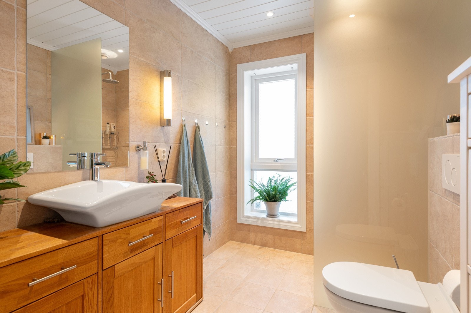 Lekkert, flislagt bad med vannbåren gulvvarme og downlights i himling. Galleribilde