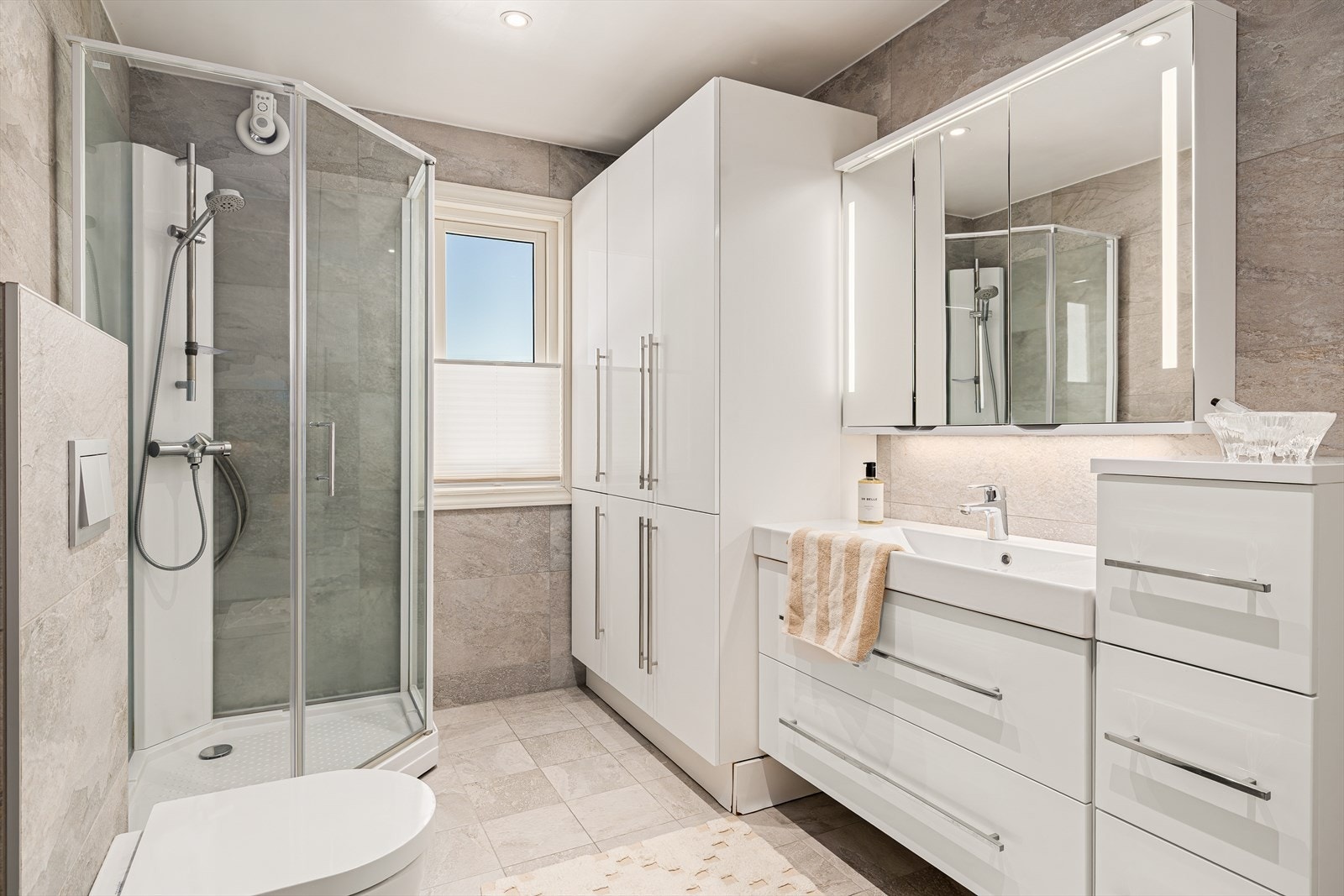 Lekkert bad/vaskerom fra 2018 med moderne uttrykk og gjennomført kvalitet. Rommet byr på romslig og funksjonell innredning, hvor både komfort og praktiske løsninger er ivaretatt - perfekt for en effektiv hverdag. Galleribilde