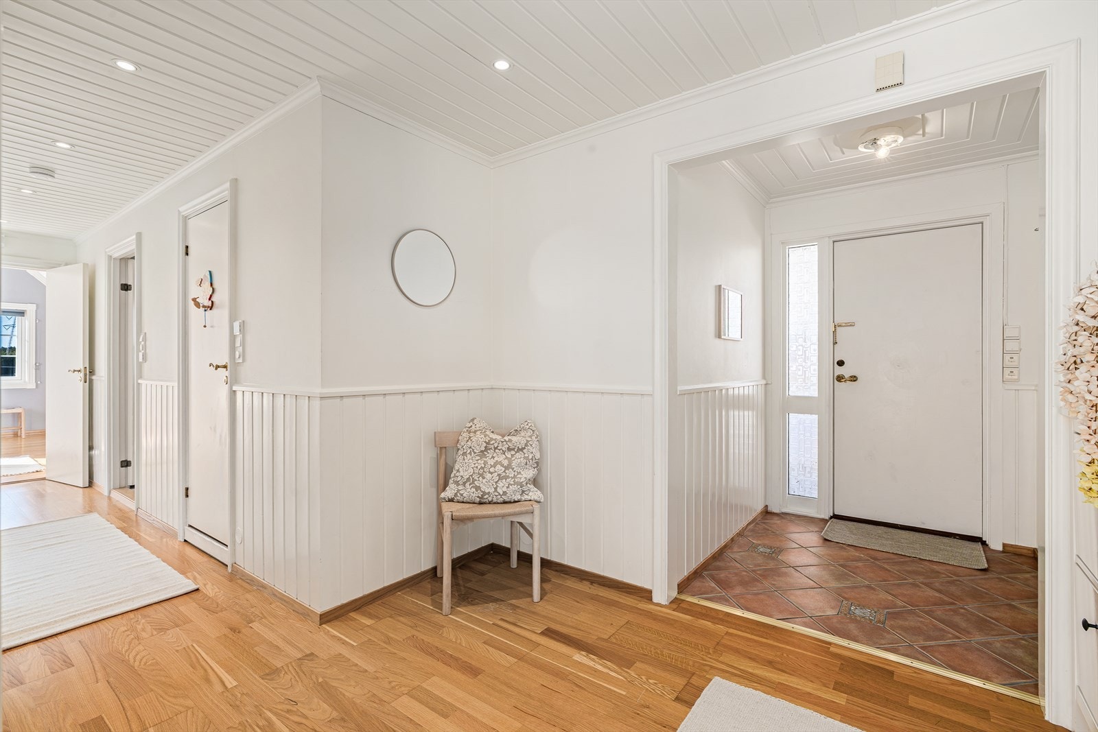 En delikat og romslig hall binder boligen elegant sammen - her møtes du av gjennomtenkte materialvalg, behagelig belysning med downlights i himlingen og en atmosfære som oser av kvalitet og velvære. Galleribilde