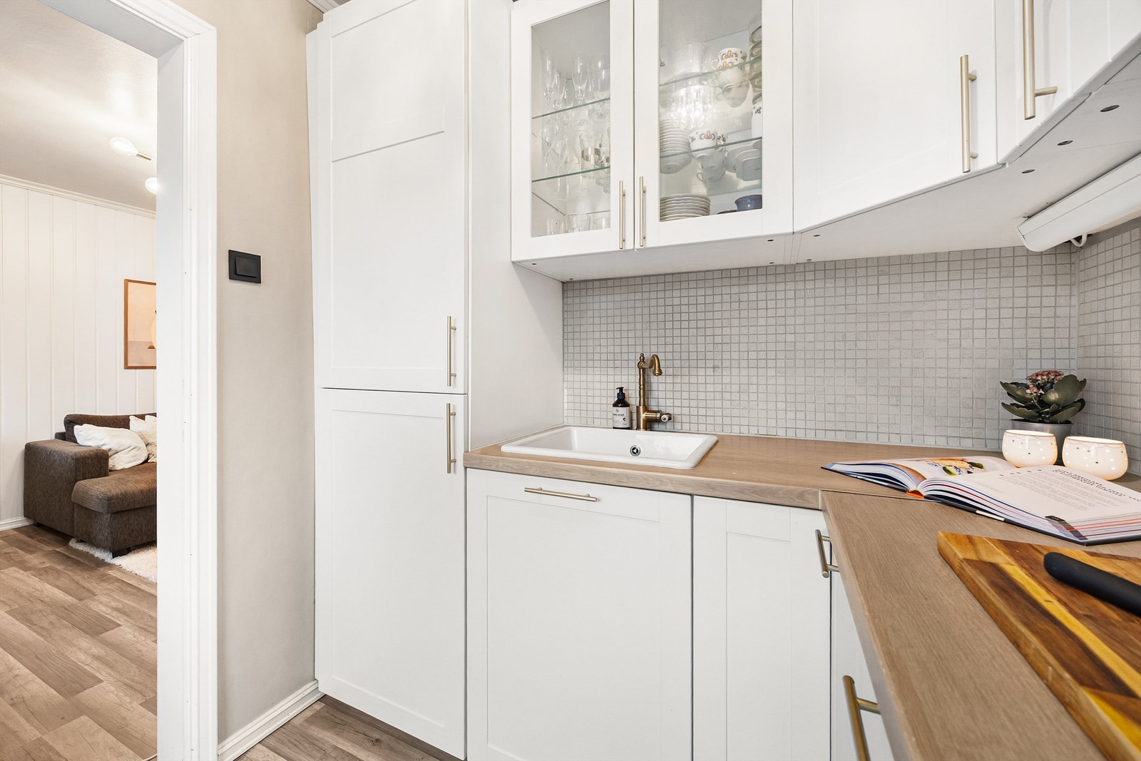 Lys kjøkkeninnredning med profilerte fronter samt glassfronter Galleribilde