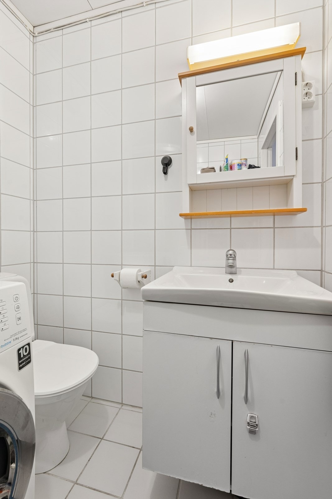 Baderom med dusjkabinett hybel, samt opplegg for vaskemaskin og plass til tørketrommel. Galleribilde