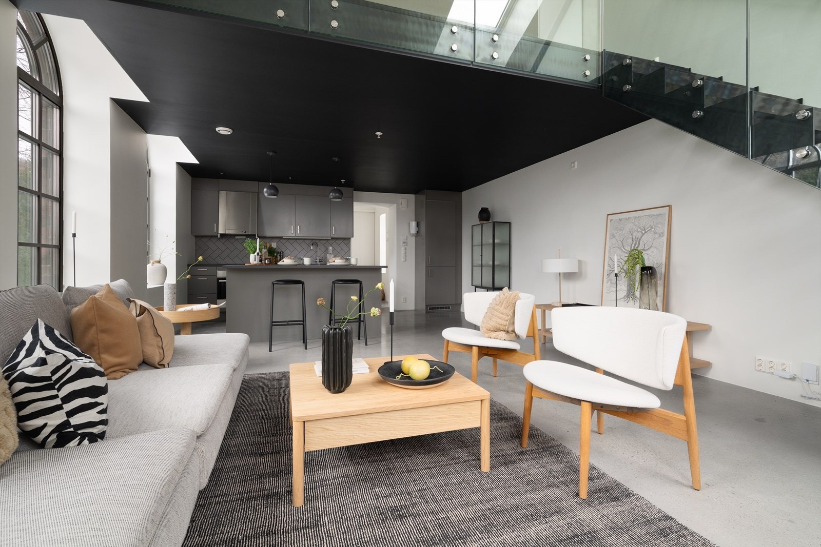 Sort eiketrapp, glass og et røft stålslipt betonggulv med vannbåren varme, gjør denne leiligheten til noe helt unikt. Galleribilde