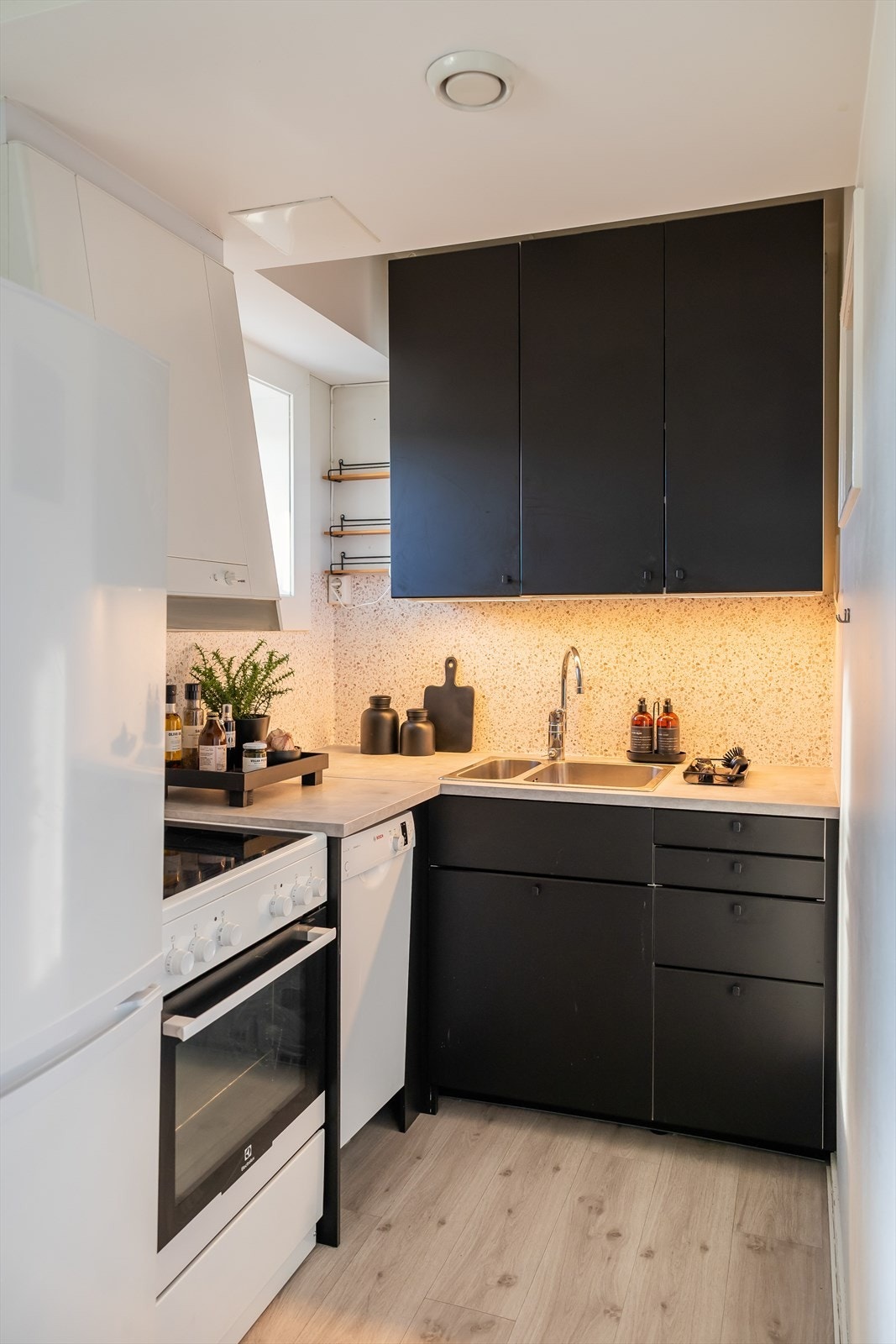 Kjøkkenet i leiligheten ble pusset opp i 2020 med ny kjøkkeninnredning og benkeplater. Beskyttelsesfolie på vegg over benkeplaten ble lagt i 2025. Galleribilde