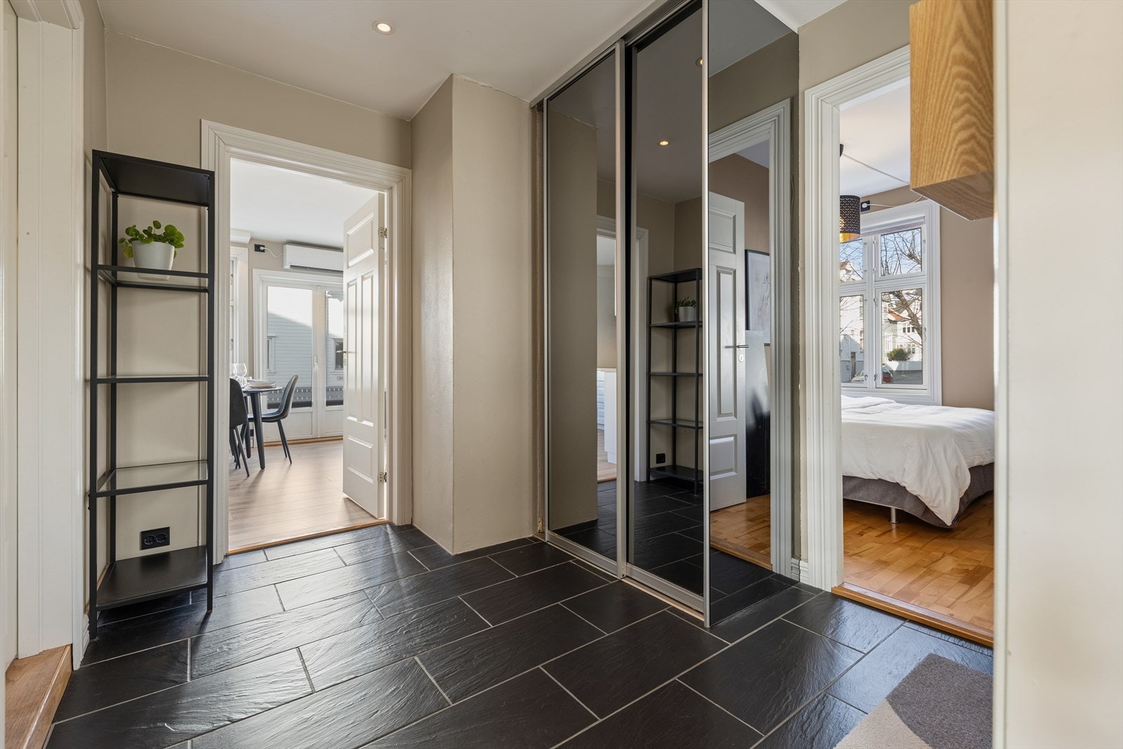 Romslig entré med skyvedørsgarderobe med speilfronter og tilgang til stort, tilhørende privat bodareal i kjeller (10 m² BRA-E) samt fellesboder. Galleribilde