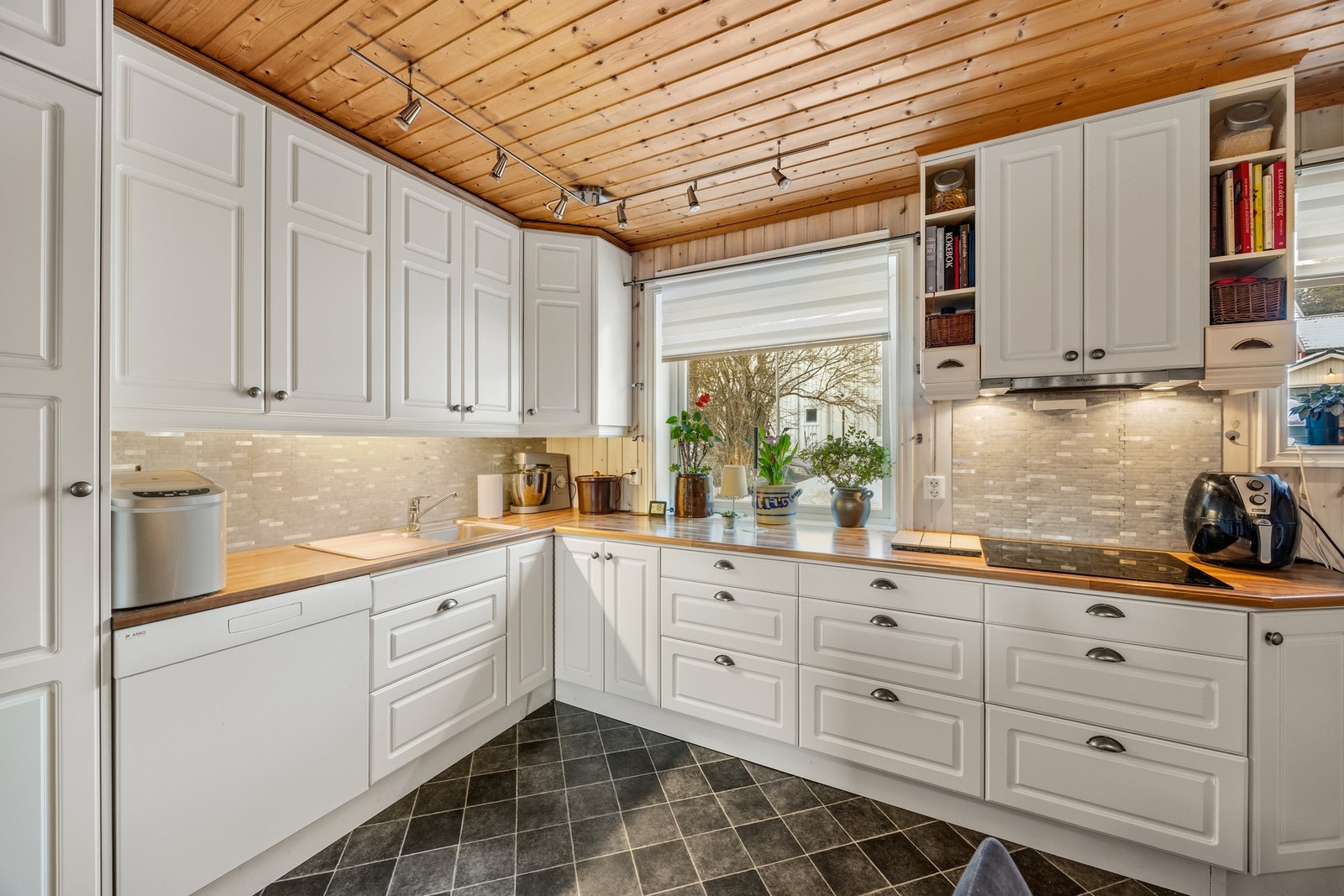 Pen innredning med integrert platetopp, stekeovn og oppvaskmaskin, samt avsatt plass for kjøleskap Galleribilde