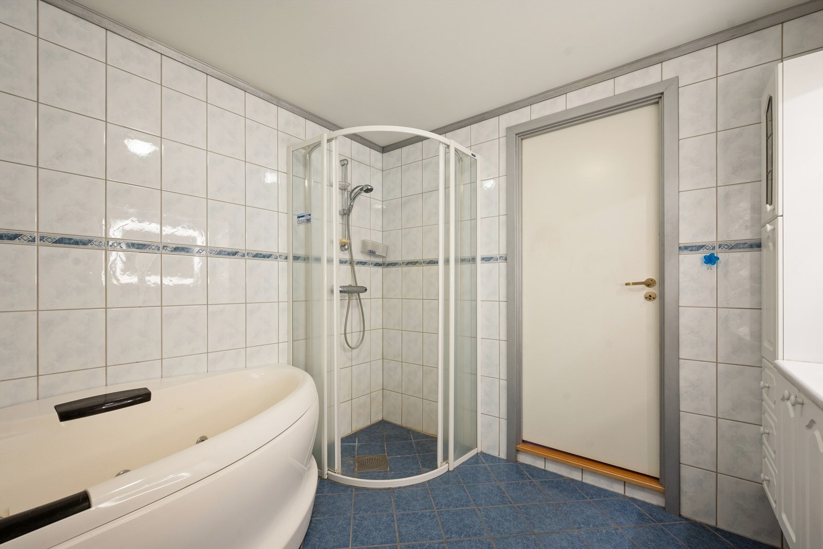 Innredningen består av speil, to servanter med baderomsinnredning med profilerte fronter, gulvstående klosett, boblebadekar og dusj med dør i herdet glass. Galleribilde