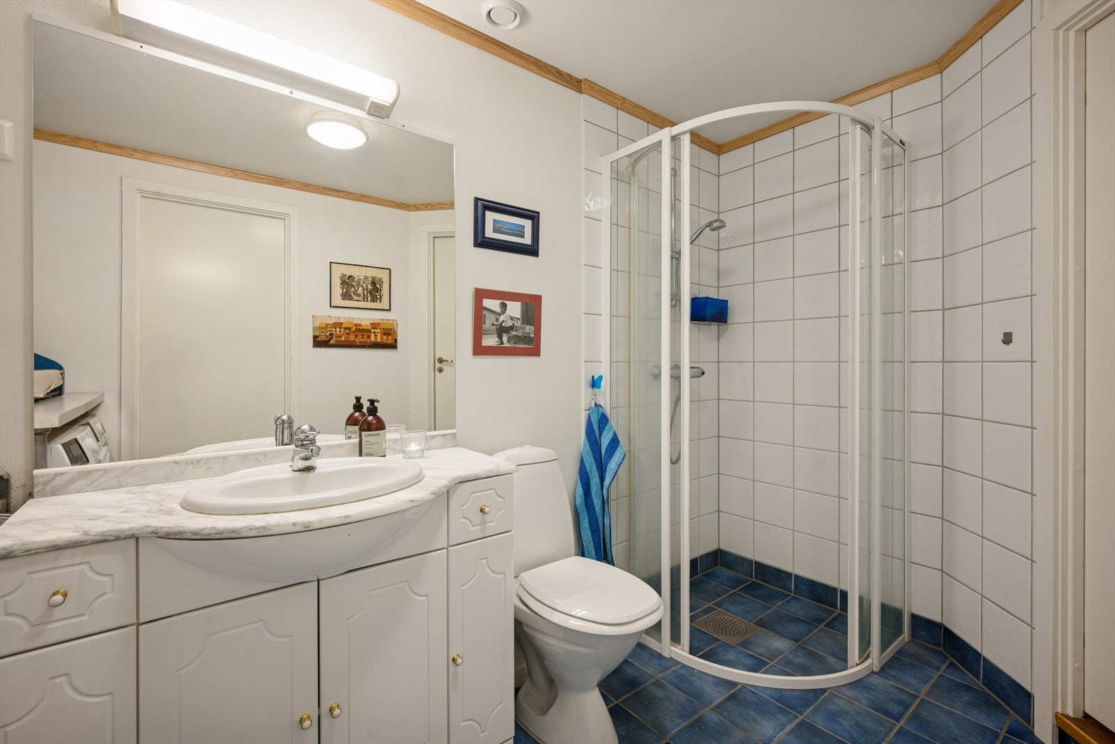 Innredningen består av speil, servant med benkeskap med profilerte fronter, veggskap med frostede glassfronter, gulvstående klosett, dusj med innfellbare dører, samt opplegg for vaskemaskin. Galleribilde