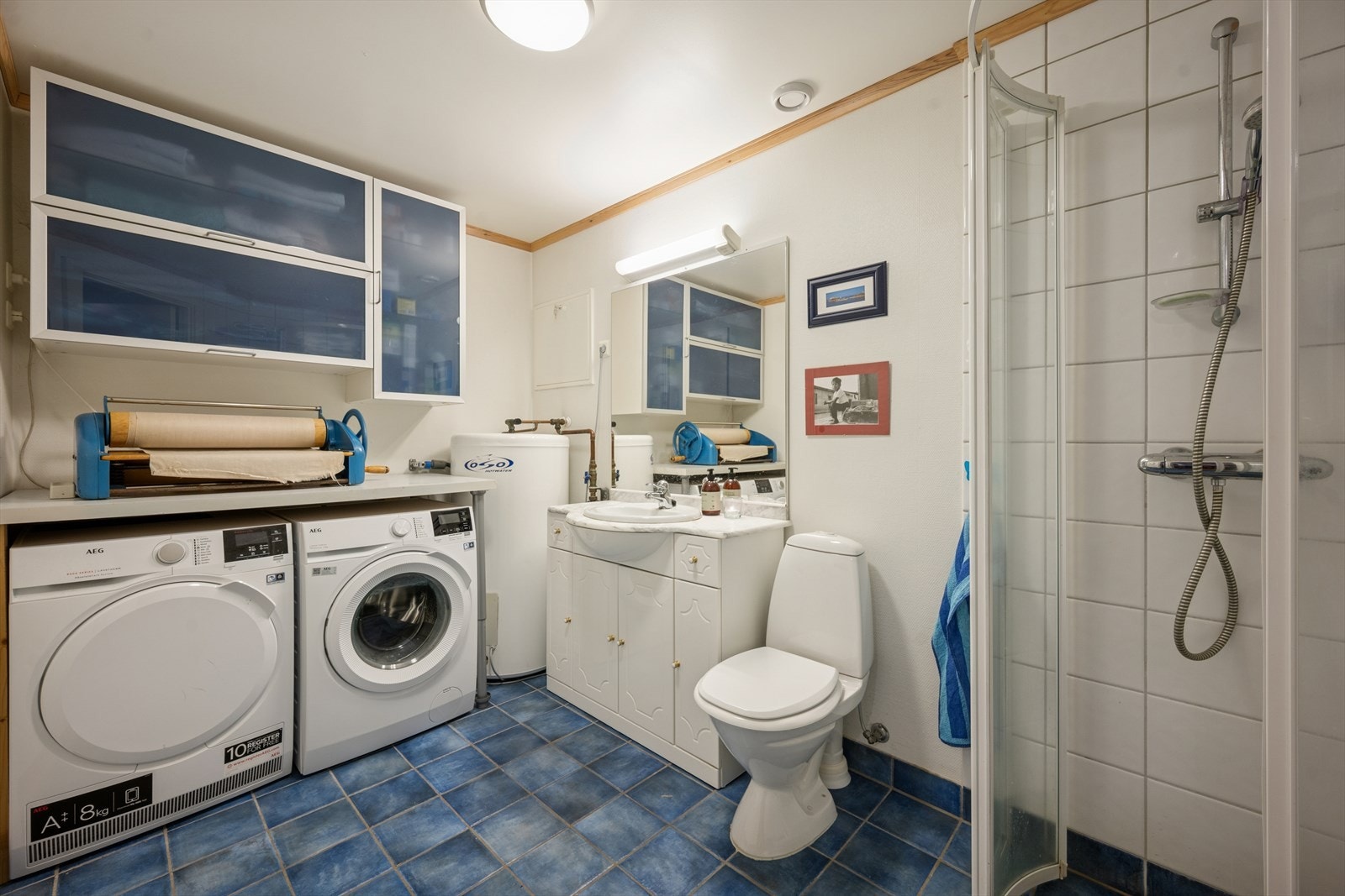 Bad/vaskerom har fliser på gulvet og i dusjsonen, med malt glassfiberstrie på de øvrige veggene. Galleribilde