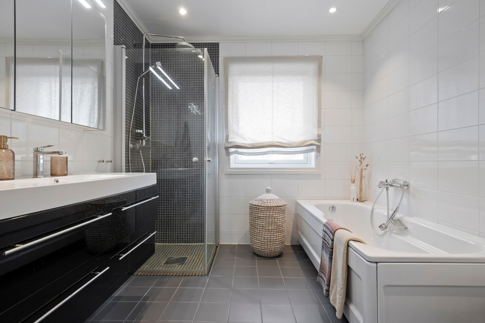 Badet i hovedetasjen har flislagte vegger og flislagt gulv med varmekabler og nedsenket dusjsone. Galleribilde