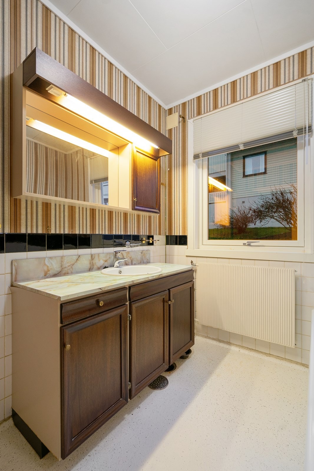 Bad 4 etg. har servant med underskap og overskap med speil og belysning. Galleribilde