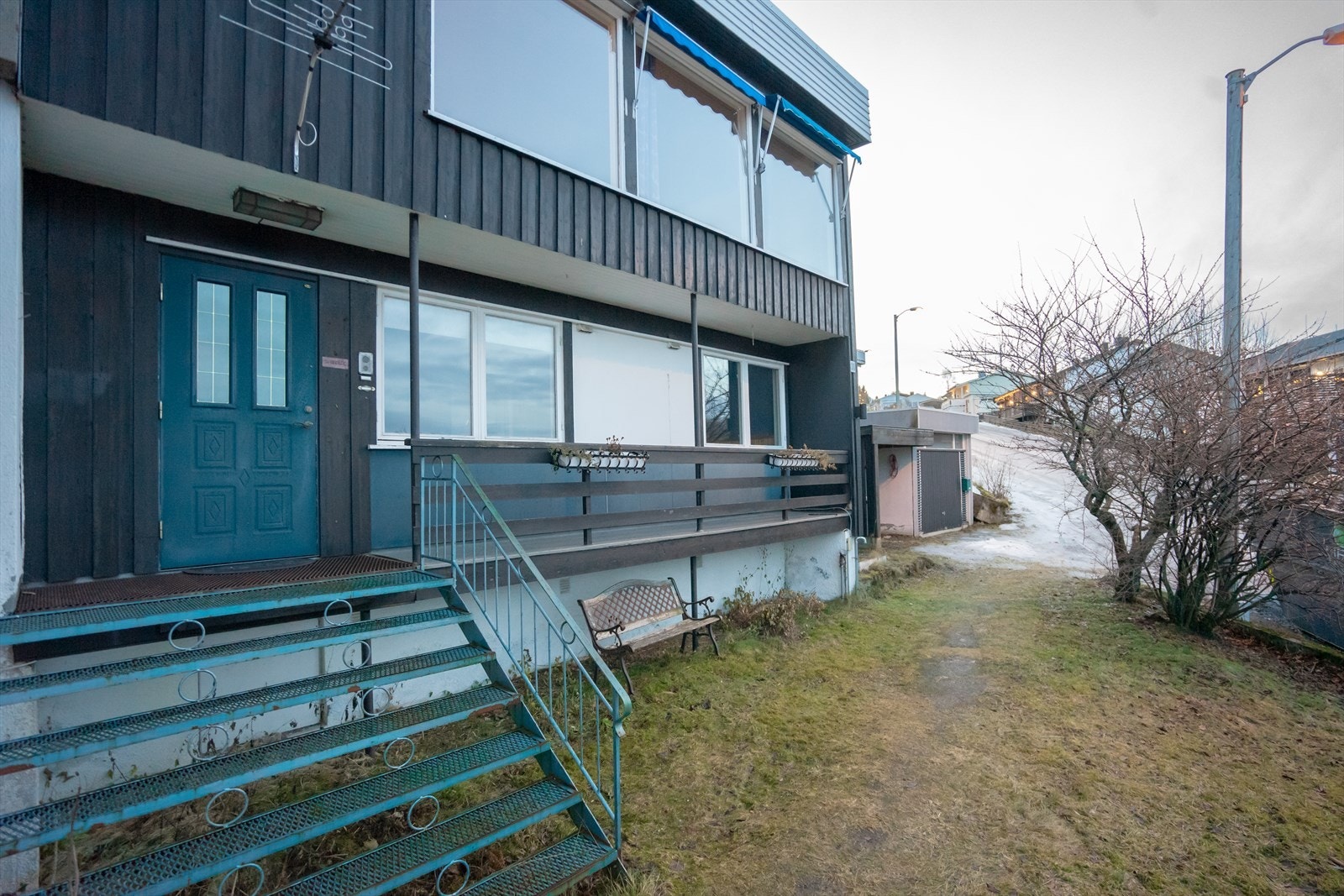 Utkraget balkong ved inngangsparti med dekke av glassfiber belagt på trebord. Galleribilde