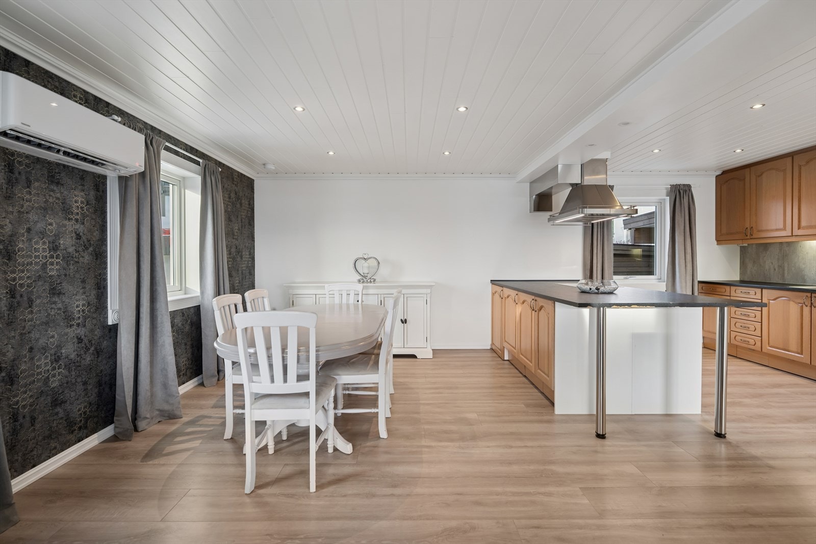 Kjøkkenet har en åpen løsning mot stue og spiseplass, noe som skaper en sosial og luftig romfølelse - perfekt for både hverdag og gjester. Downlights i himlingen gir en jevn og behagelig belysning og bidrar til et moderne uttrykk. Galleribilde