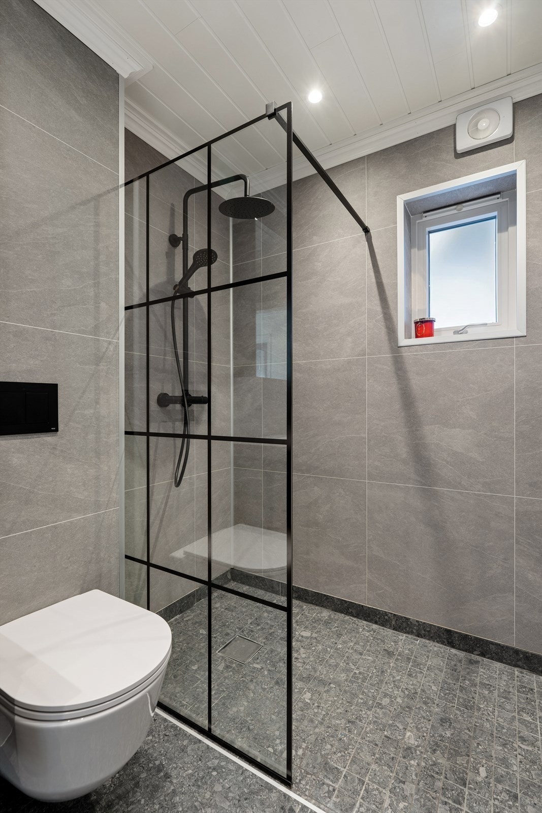 Badet har baderomsinnredning med heldekkende servant og glatte fronter, speilskap og vegghengt toalett som gir et ryddig uttrykk. Det har også et dusjhjørne med glassvegg samt opplegg for vaskemaskin Galleribilde