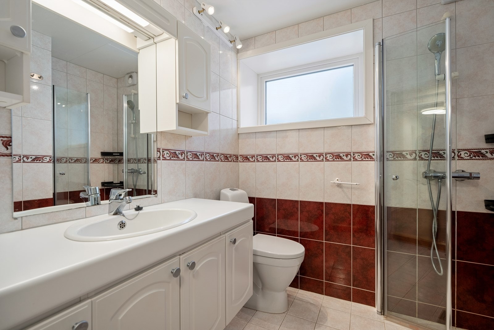 Badet i kjelleretasjen fremstår som et praktisk og velholdt rom, med helfliste vegger og gulv som gir et tidløst og robust uttrykk. Gulvvarme sørger for en behagelig varme og økt komfort, spesielt på kjølige dager. Galleribilde