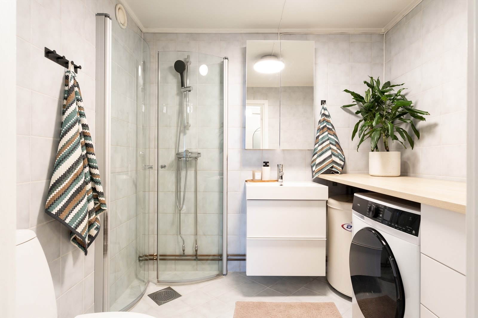 Stort, flislagt bad med gulvvarme og mekanisk avtrekk. Rommet har innredning med nedfelt servant, speilskap, toalett og dusjhjørne. Galleribilde