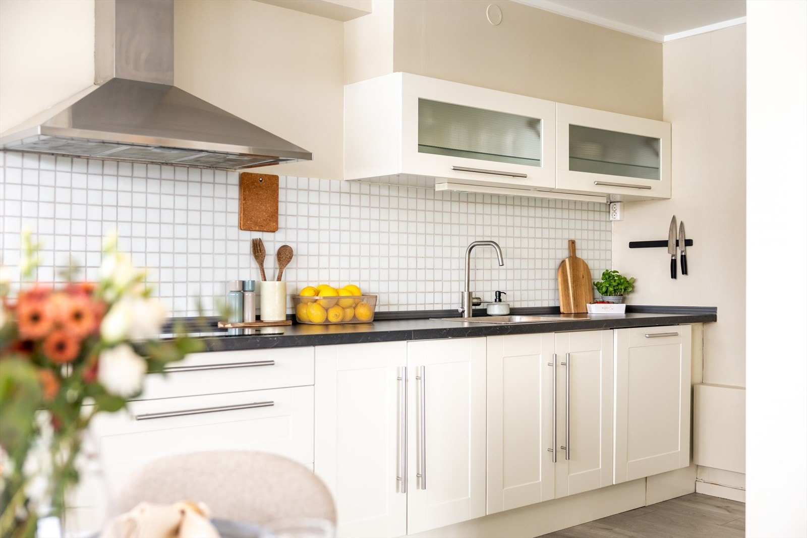 Tidløs innredning med profilerte fronter, laminat benkeplate, nedfelt kum og integrerte hvitevarer. Galleribilde