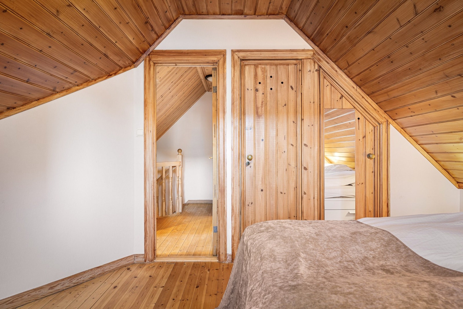 Soverom på loftet med tradisjonelle materialvalg og god romfølelse. Integrert skapplass. Galleribilde