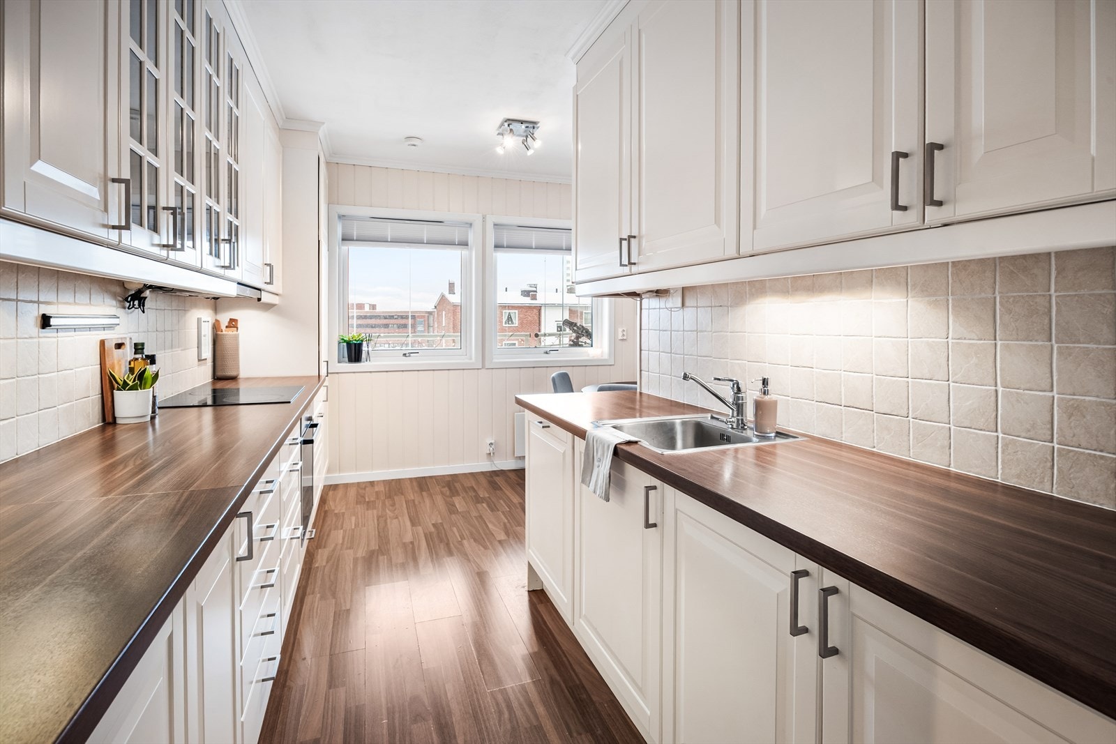 Leiligheten har en pen og velholdt kjøkkeninnredning med lyse fronter og benkeplate som går god flyt med gulvet - Praktisk med egen spisestue - krok innerst på kjøkkenet Galleribilde